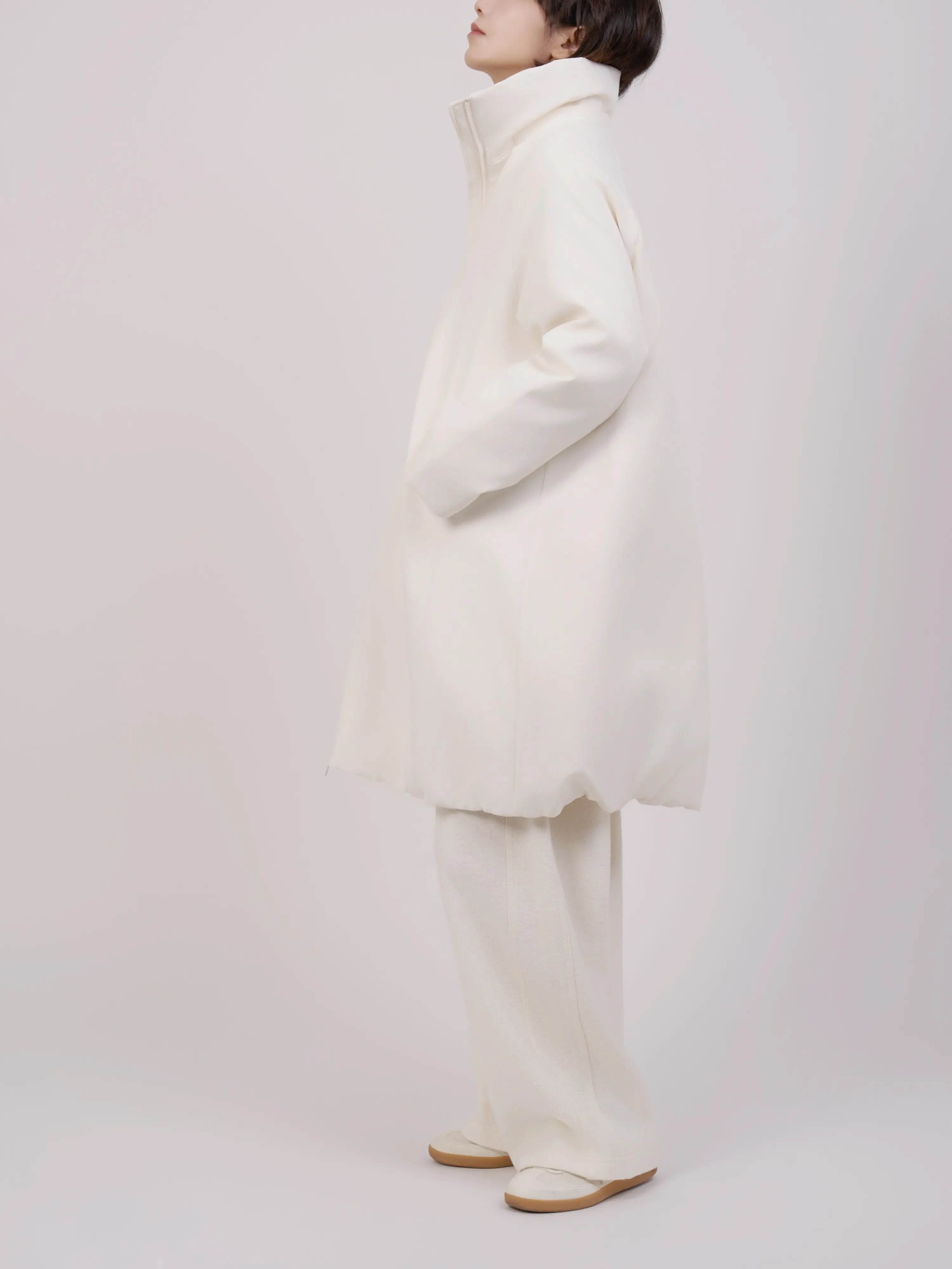 Clean side view of hooded down coat with relaxed proportions.