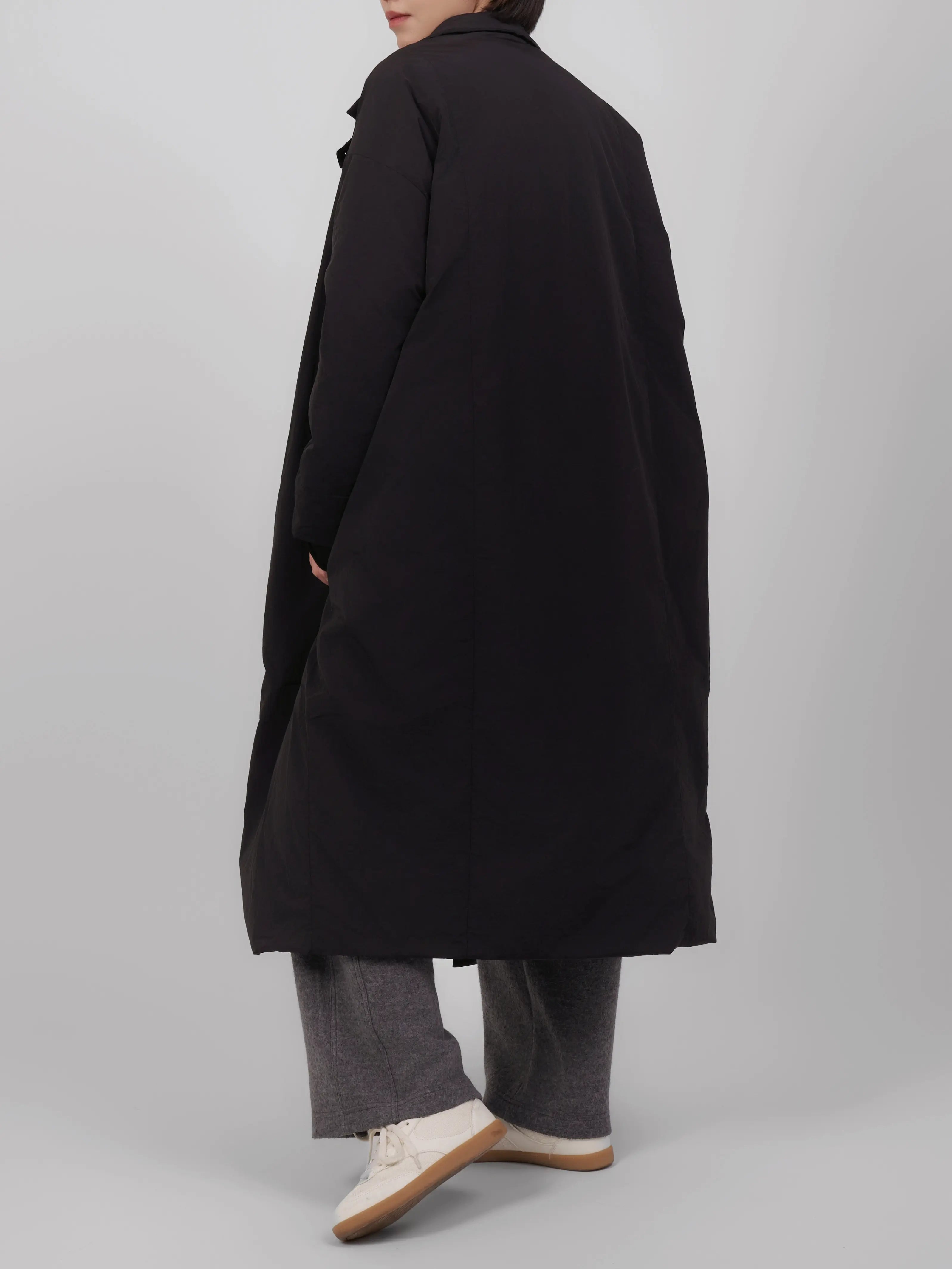 Back view of oversized down coat with a structured yet soft silhouette.