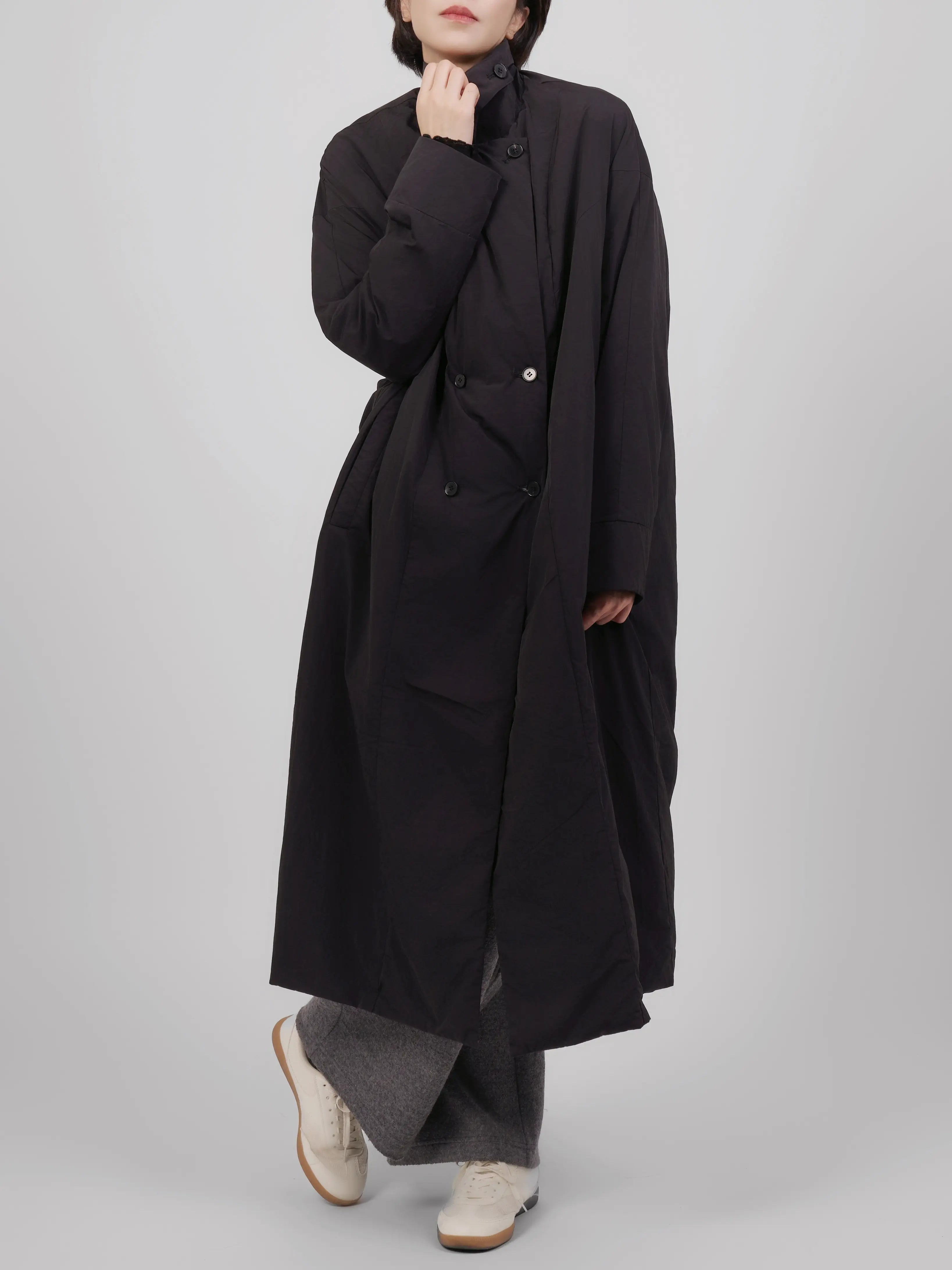 Front view of black oversized down coat featuring a clean structure and soft volume.