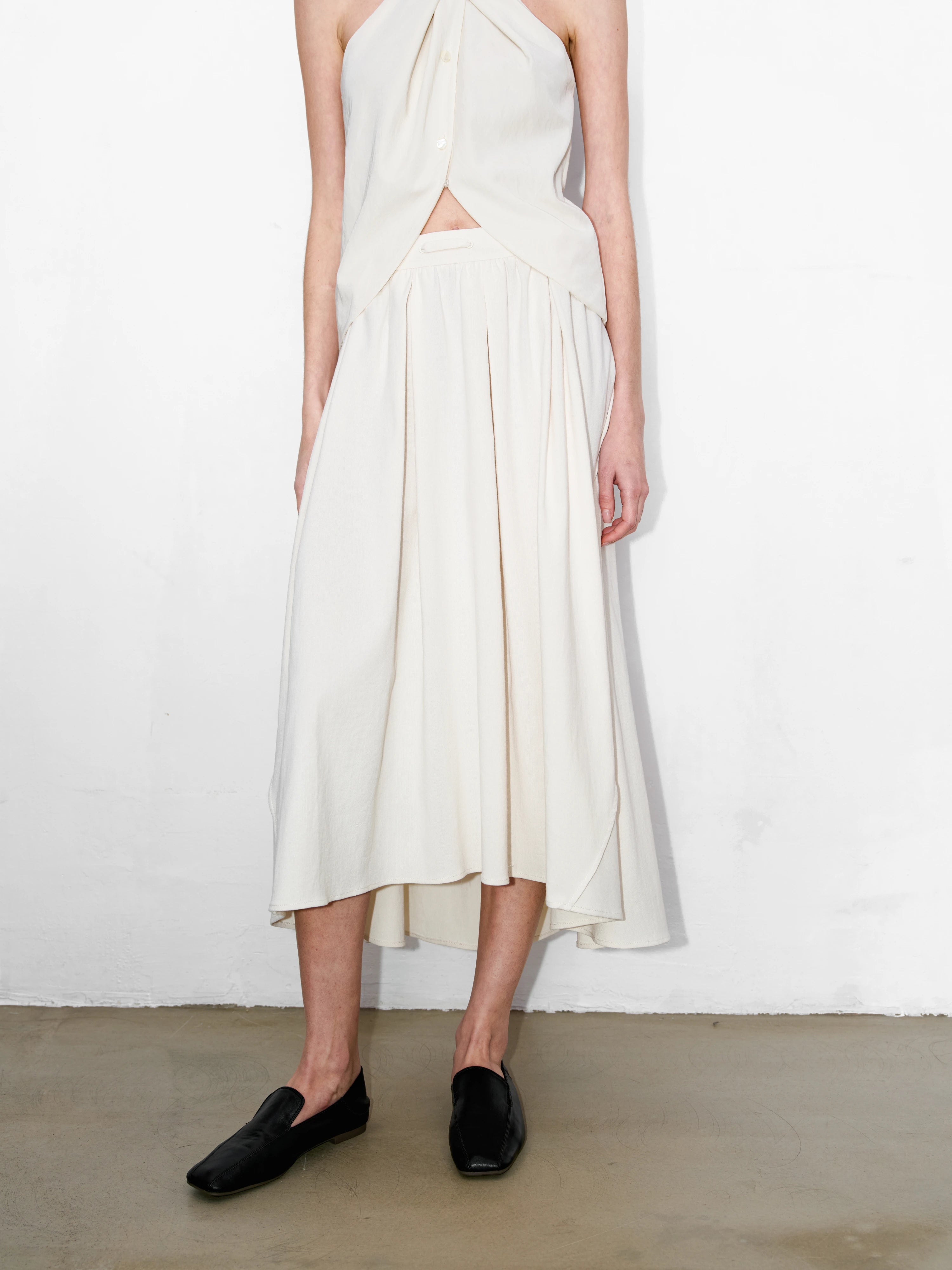 Front view of ivory cotton-linen skirt, flowy shape with adjustable waist, minimal clean styling for daily wear.