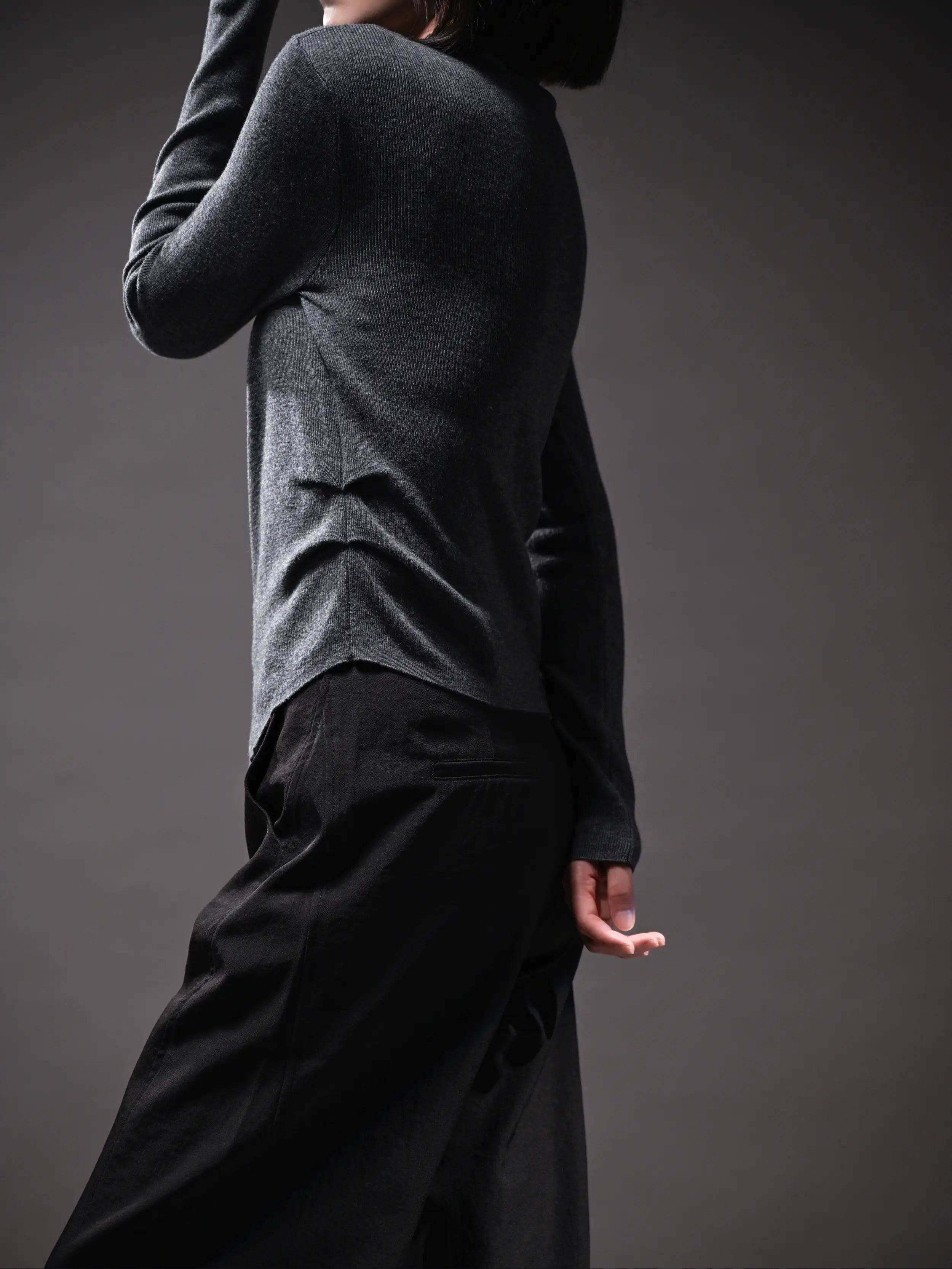 Close-up angle of grey wool top showing texture, subtle waist shaping, versatile seasonal layering piece.