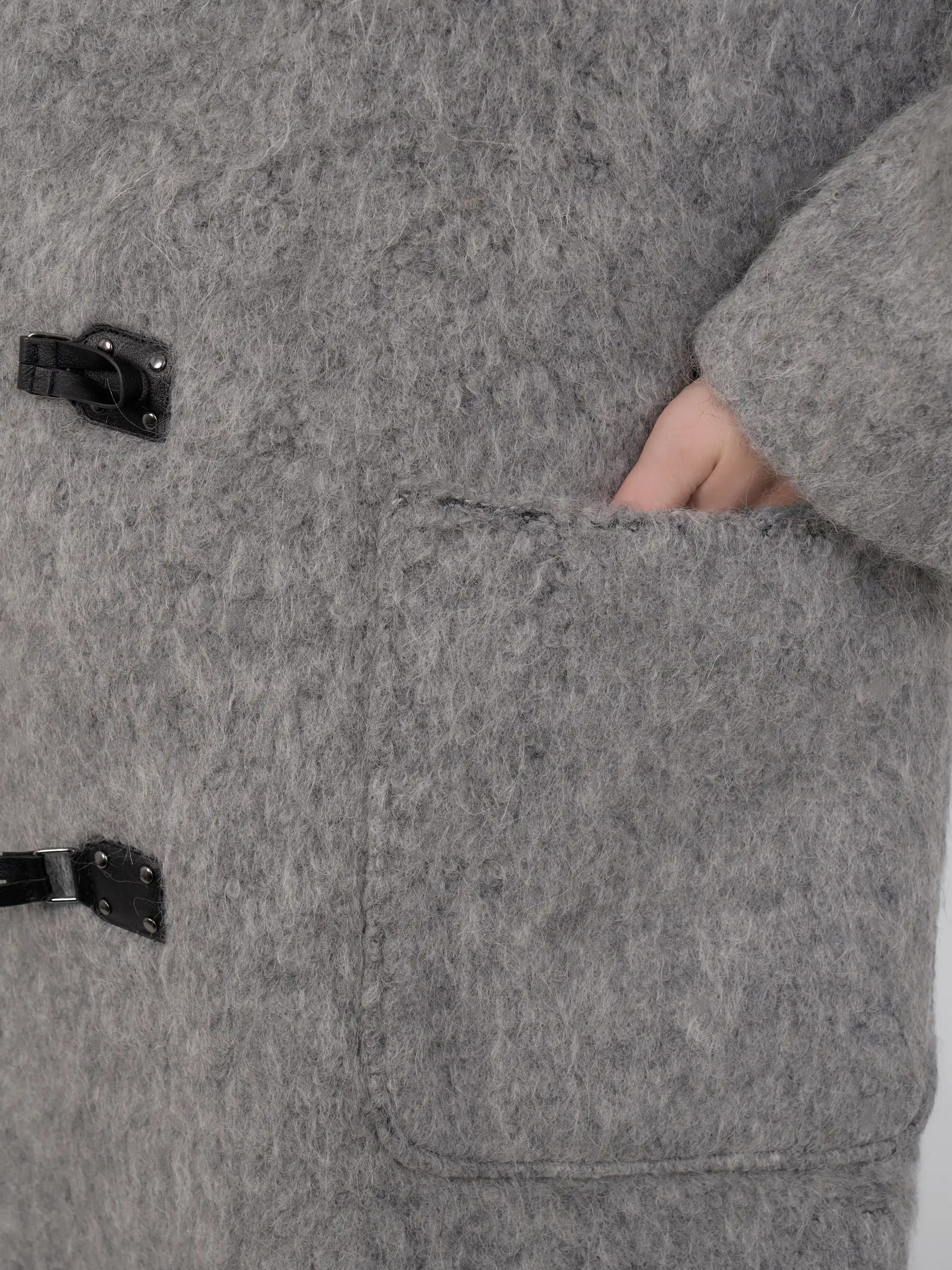 Close-up of pocket and toggle detail, highlighting fabric texture and craftsmanship.