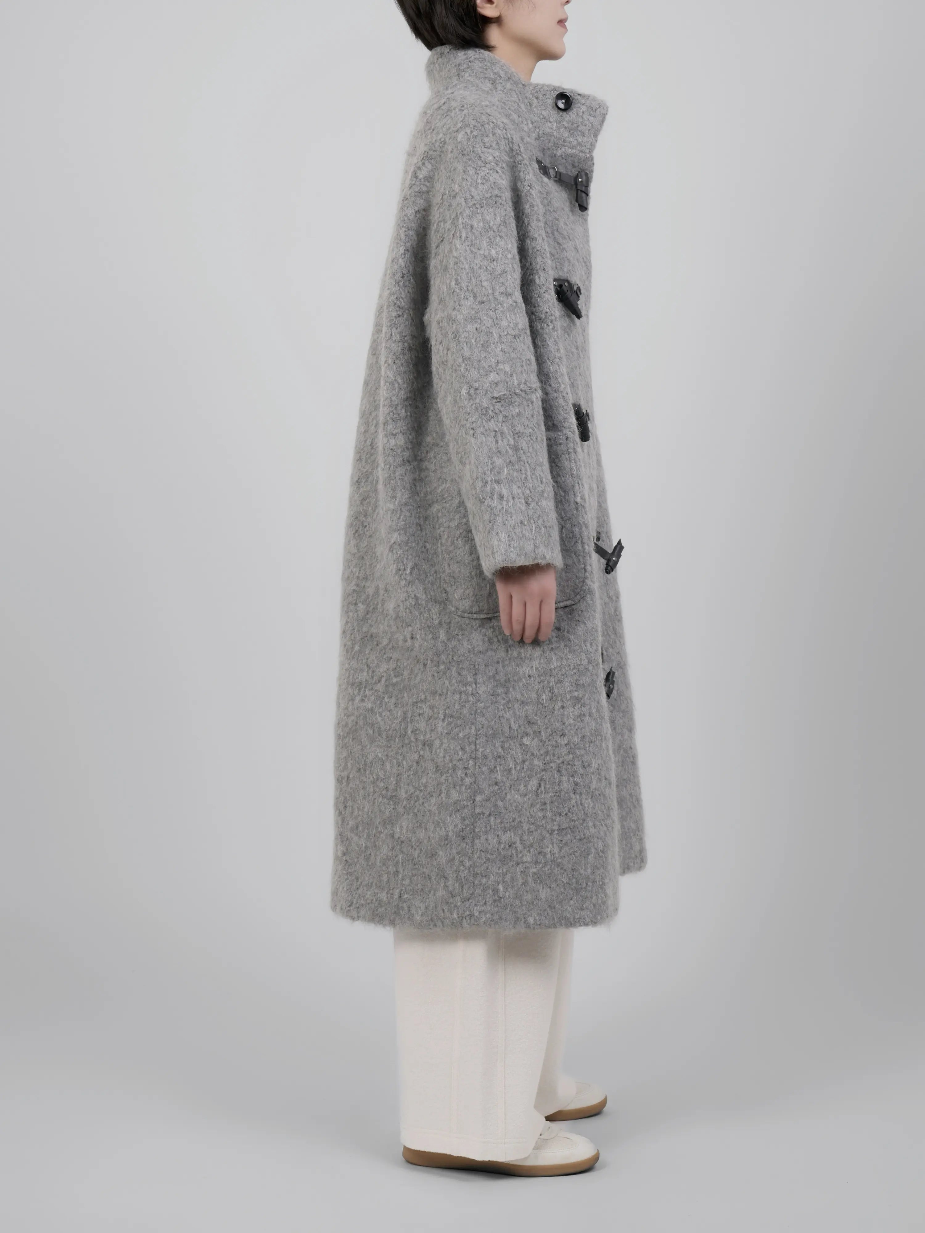 Side view highlighting the length, structure and soft drape of the coat.