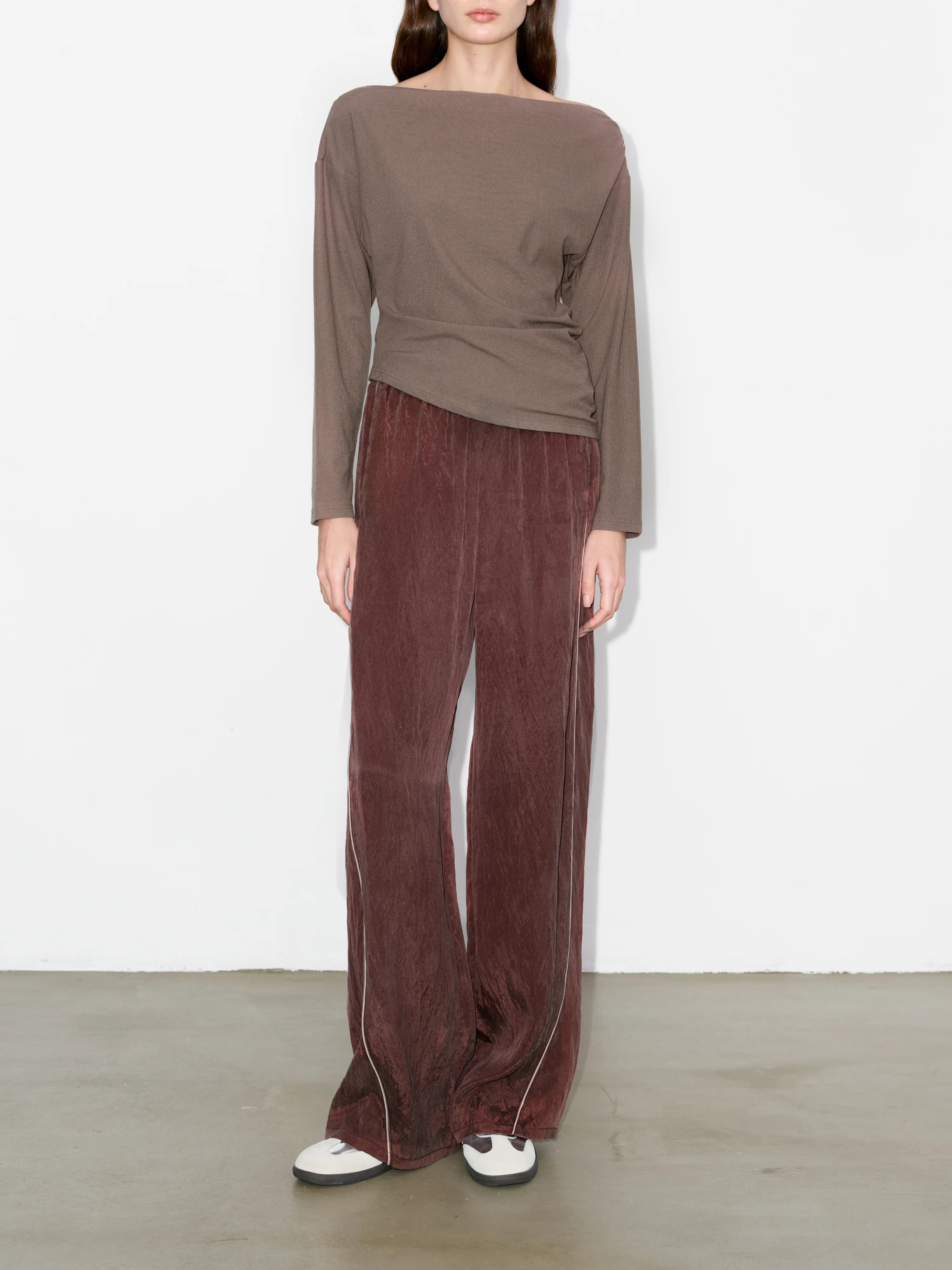 Brown irregular hem top full-body view, paired with brown wide-leg trousers, minimal neutral styling for everyday wear.