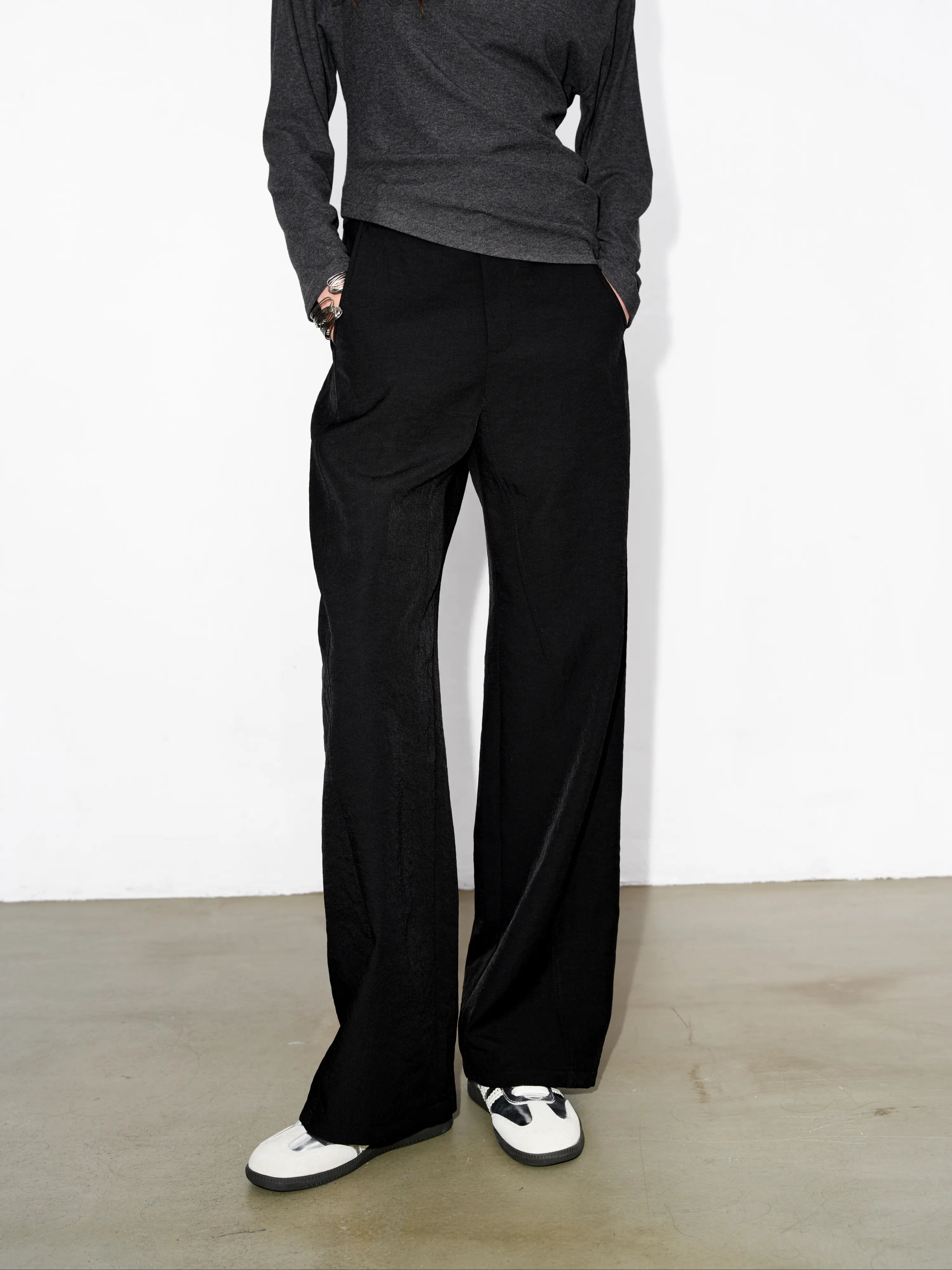 Model wearing black Japanese hollow yarn cocoon trousers, full body front view, loose silhouette, matte texture, styled with grey knit top for everyday minimal outfits.