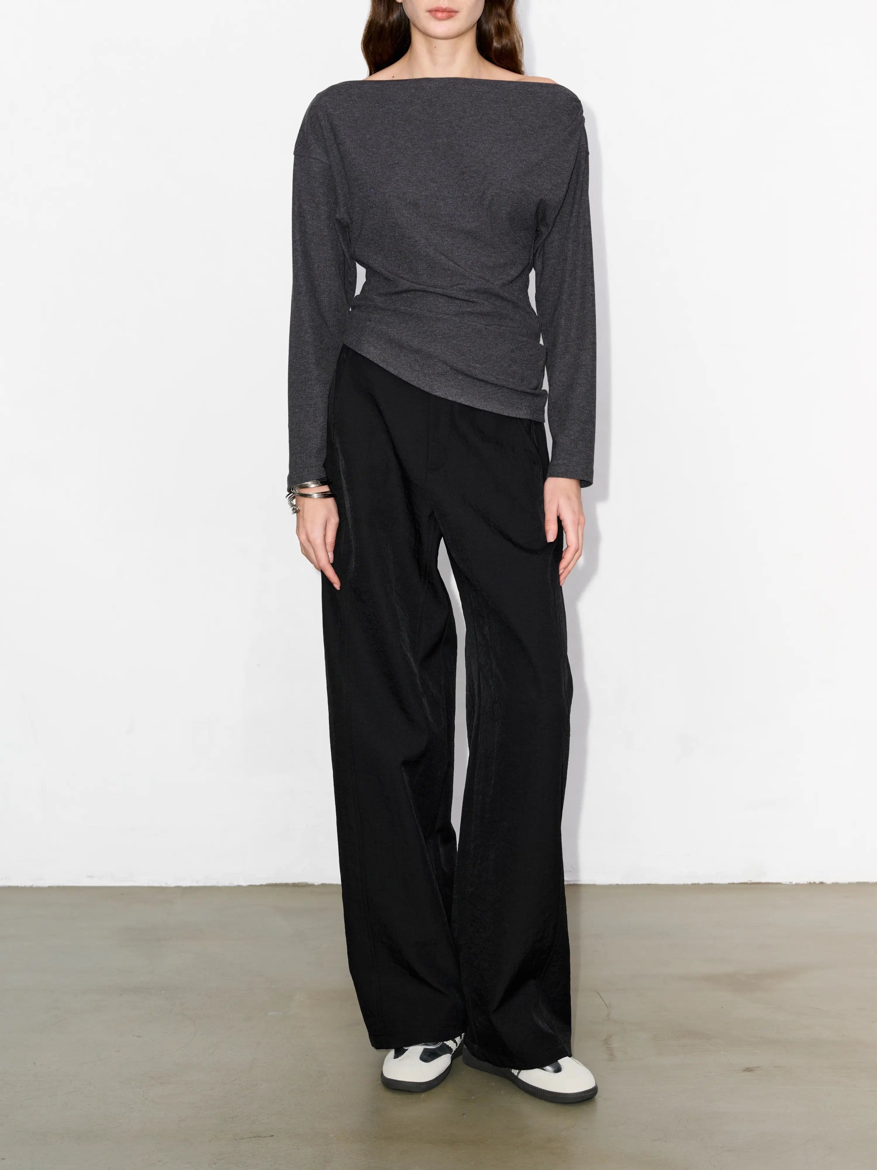 Full body front shot of black hollow yarn cocoon trousers, high comfort fit, clean line and balanced shape for daily work or travel.