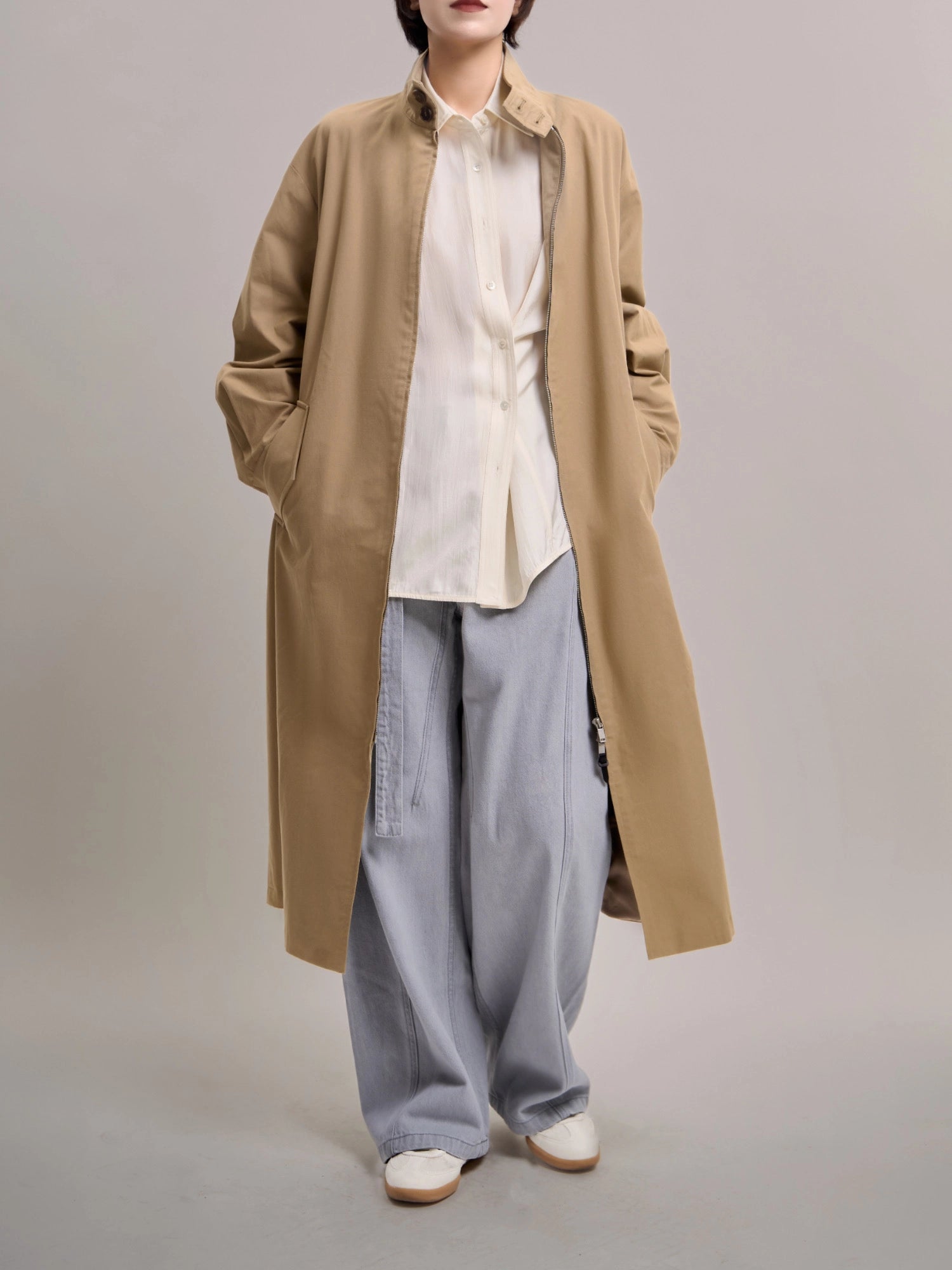 Front view of khaki trench coat styled with wide-leg pants, showing a clean, minimalist full-body city outfit.