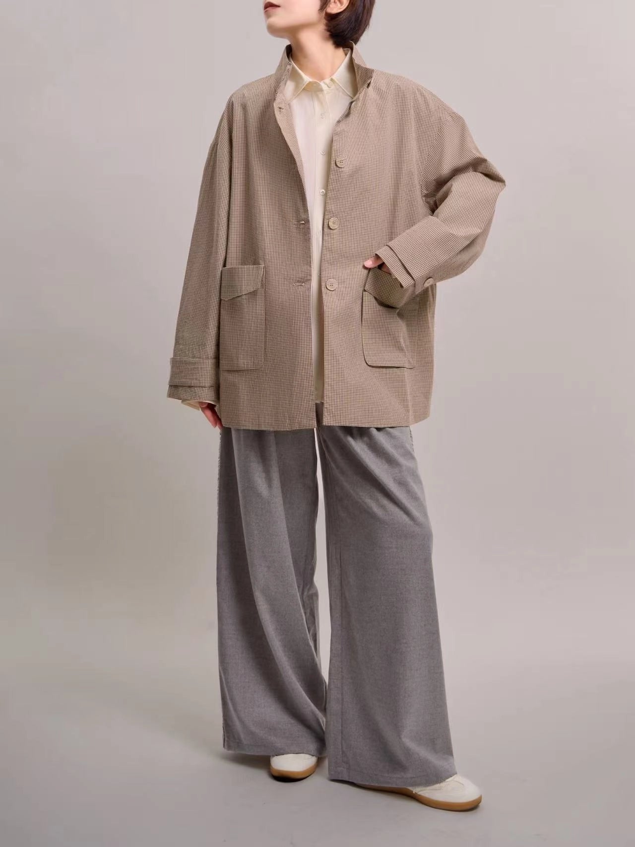 Front full-body view of beige minimal check jacket, showing relaxed dropped-shoulder silhouette and clean cotton texture.