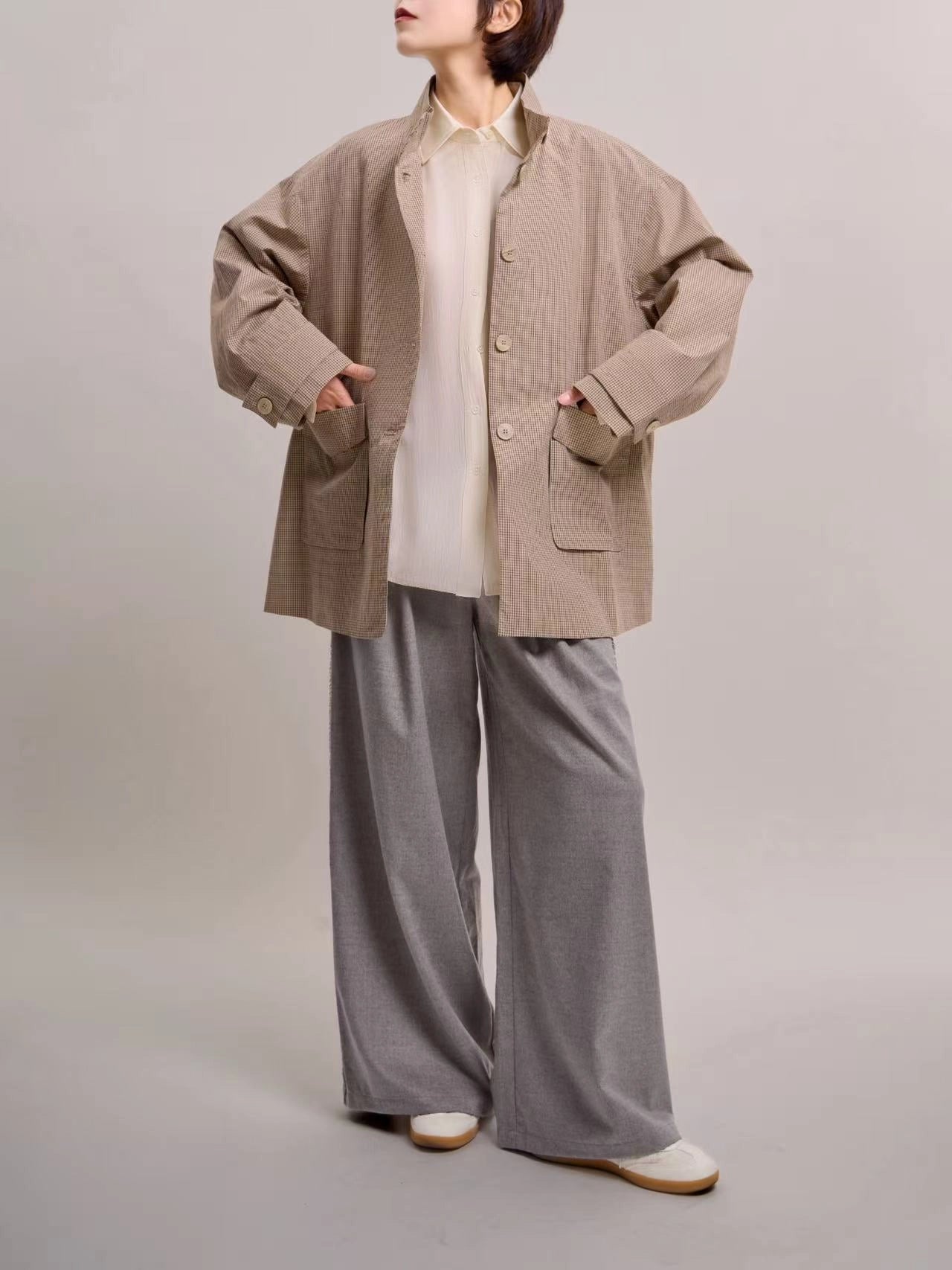 Beige minimal check jacket front view styled with wide-leg trousers, highlighting soft structure and easy seasonal layering.