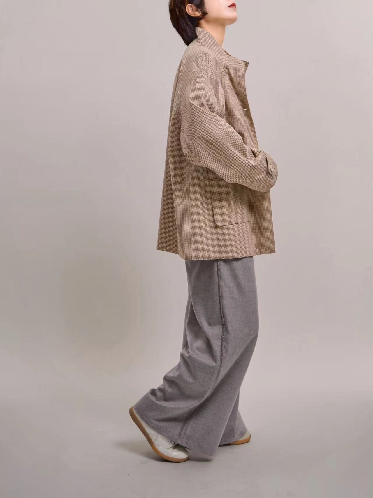 Side profile of beige minimal check jacket, highlighting relaxed shoulder line and soft everyday structure.
