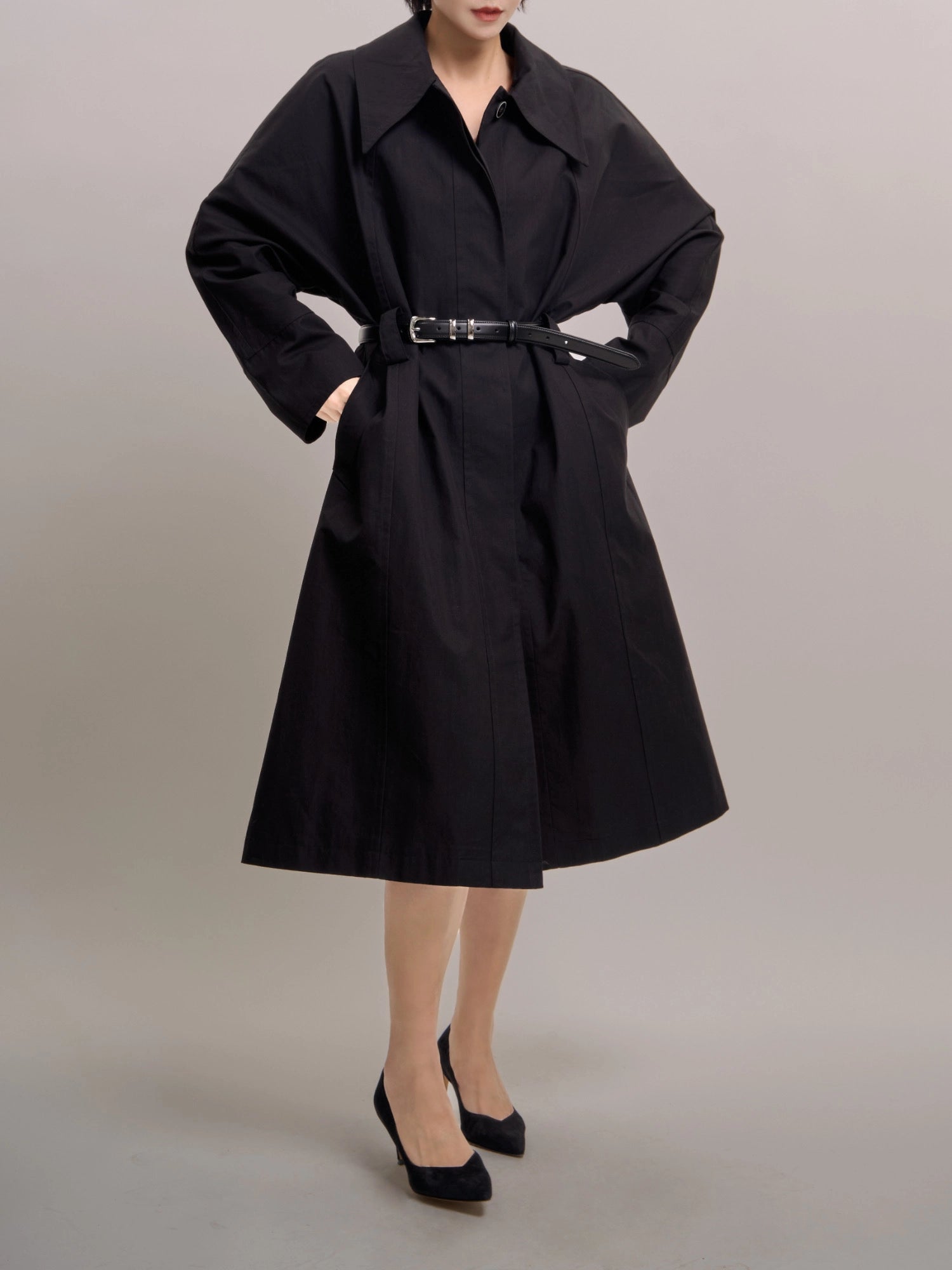 Front view of Noir Trench in black, showing batwing sleeves and belted waist for a clean structured silhouette.