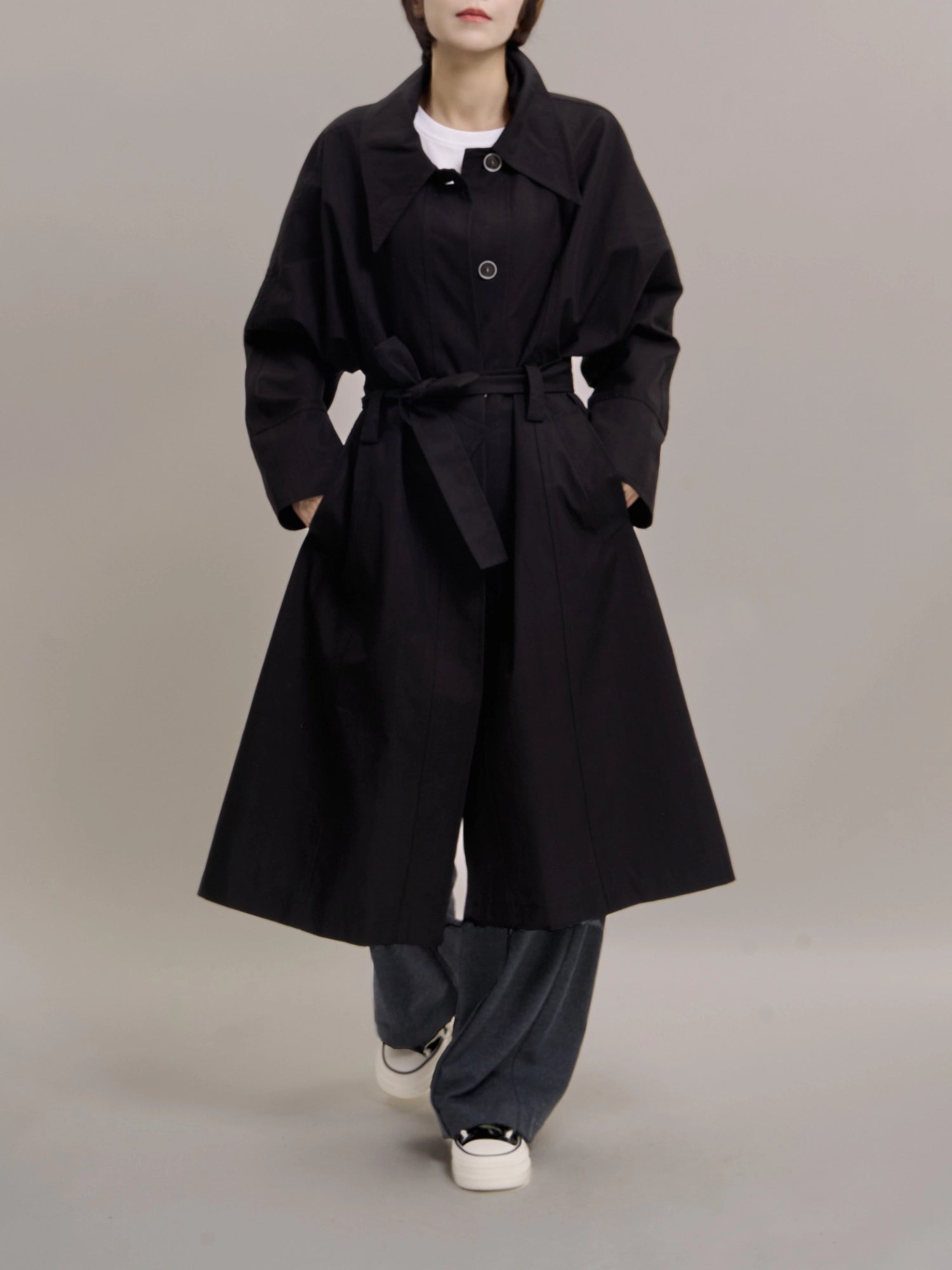 Relaxed front view of Noir Trench styled with casual trousers, emphasizing versatile everyday wear.