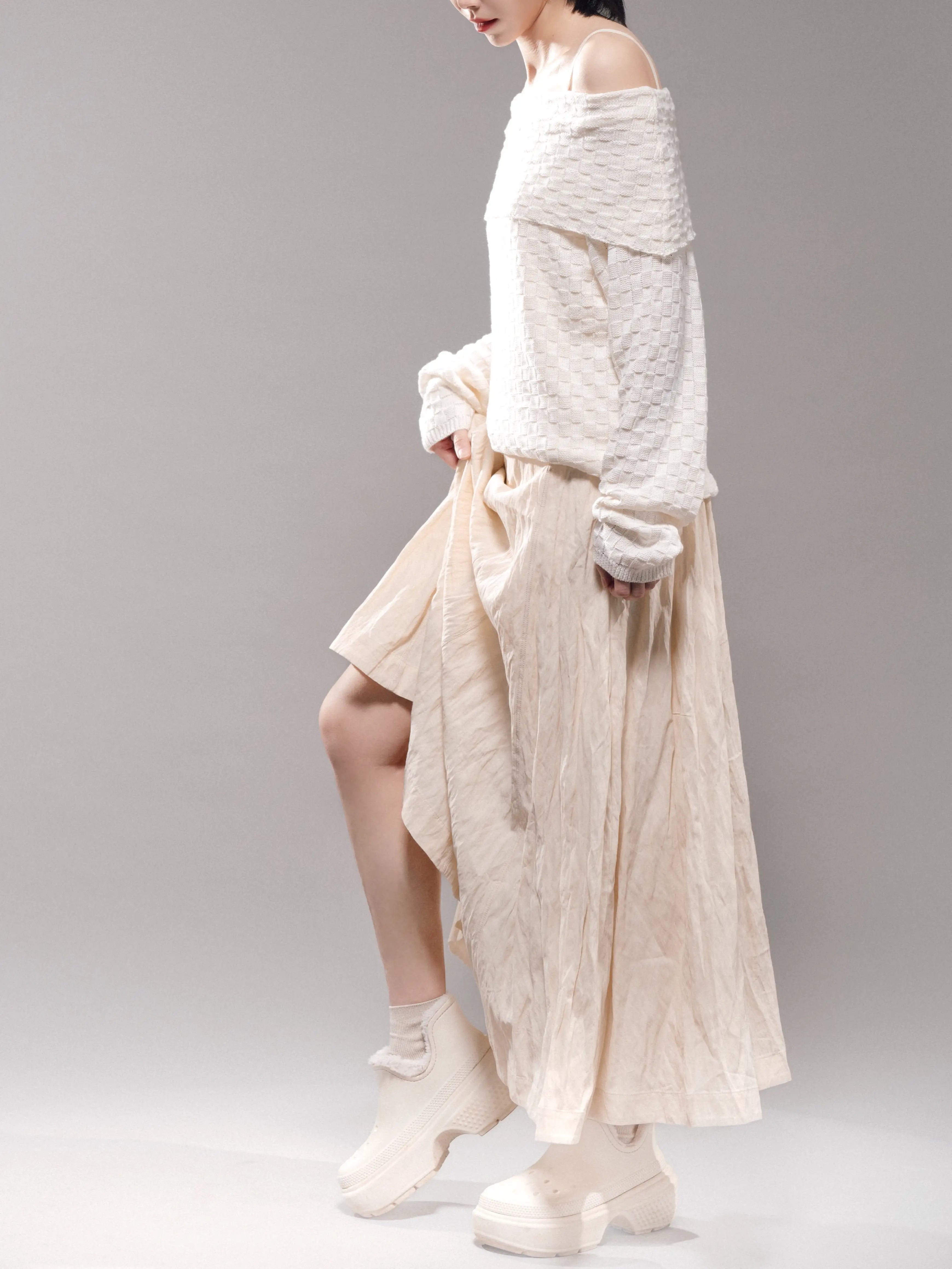 Light ivory off-shoulder knit top, right side styling view with skirt, casual soft silhouette suitable for everyday wear.
