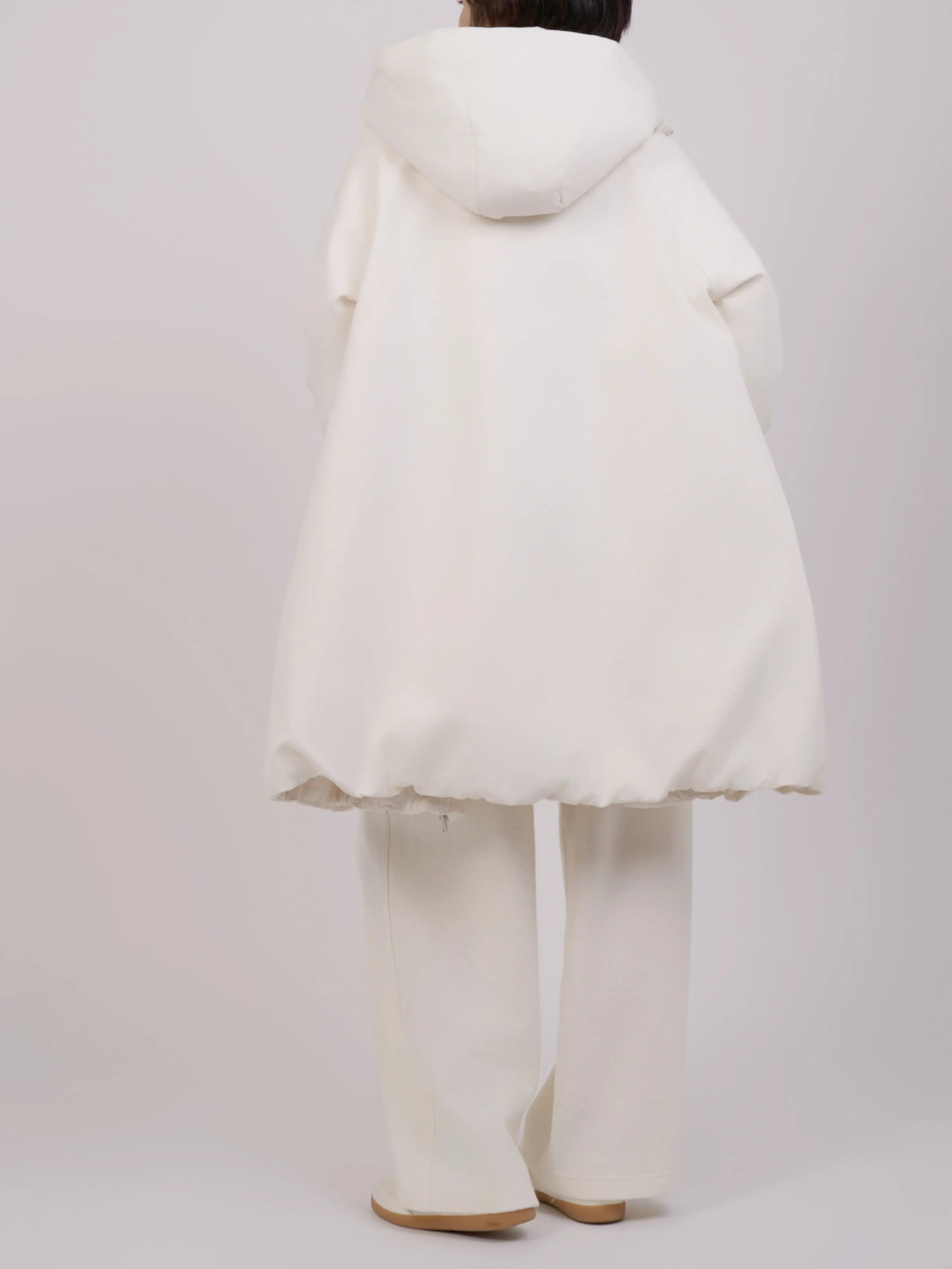 Back view of off-white down coat featuring a soft rounded silhouette and hood detail.