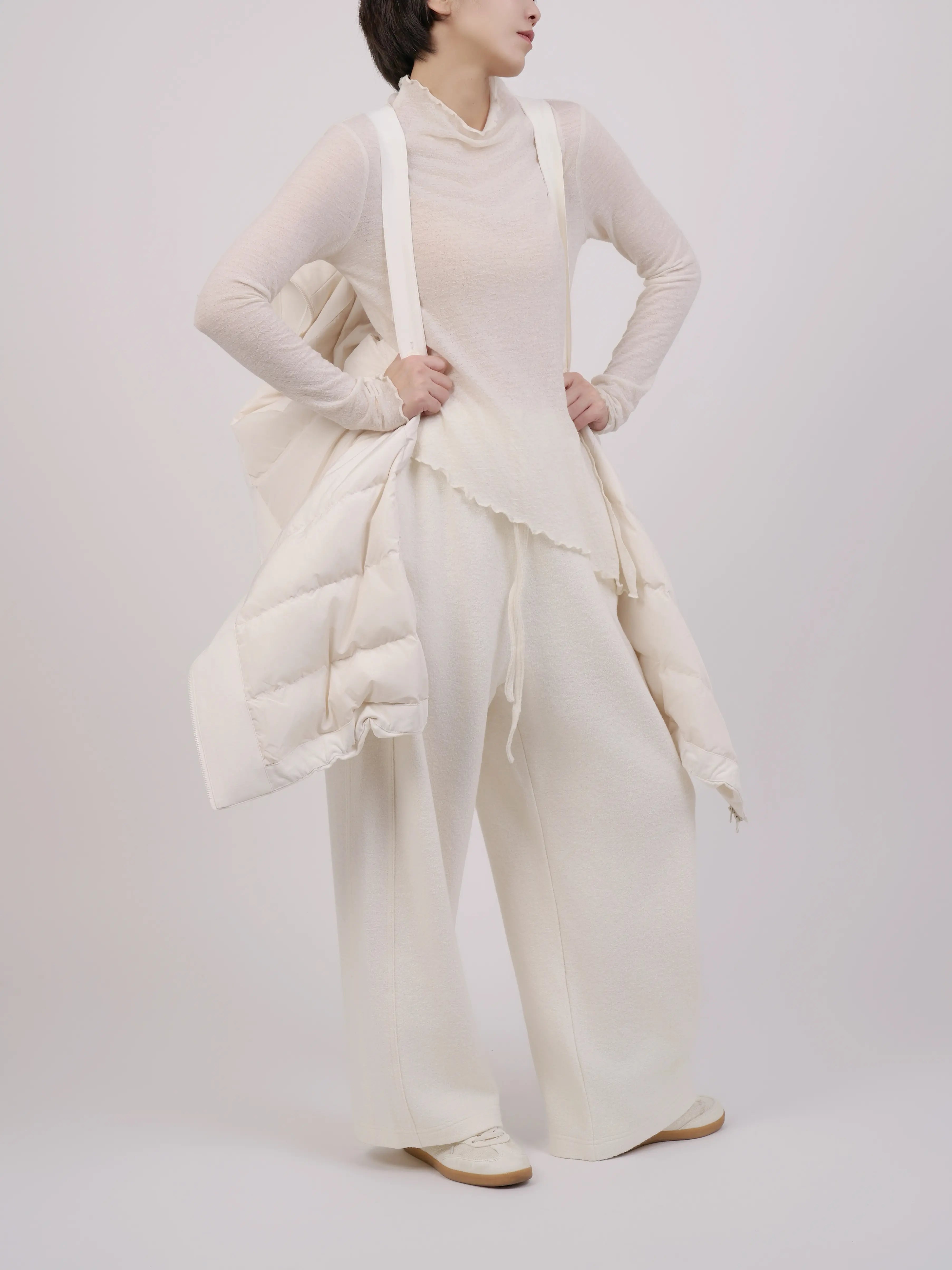 Movement shot highlighting the flow and lightweight volume of the down coat.