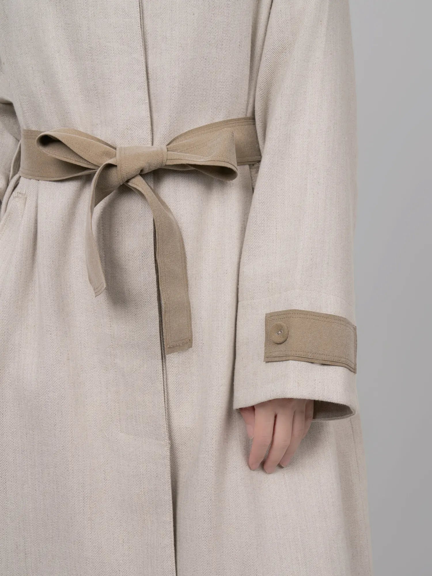 Close-up of belt detail showing texture contrast and tie design.