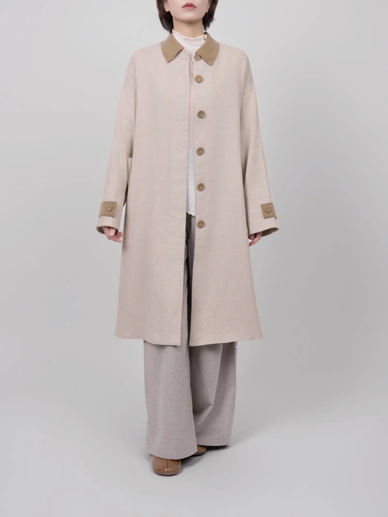 Front view of linen-wool coat in a natural neutral tone with a clean straight cut.