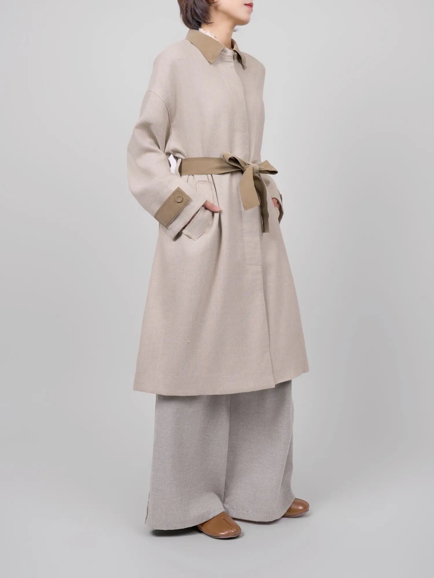 Side detail of the coat emphasising relaxed fit and natural structure.