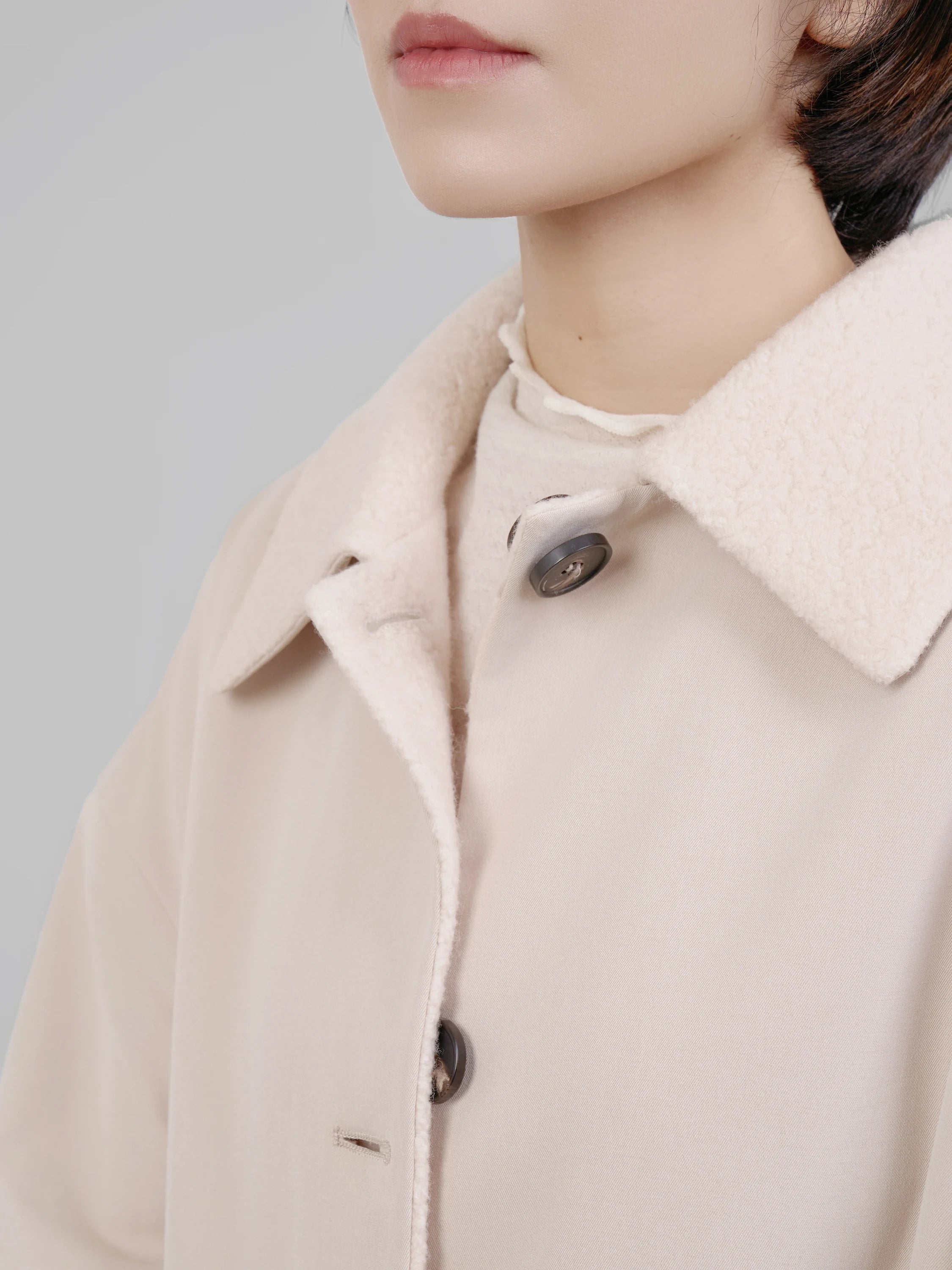 Close-up of collar and neckline, showing soft wool texture and button detail.