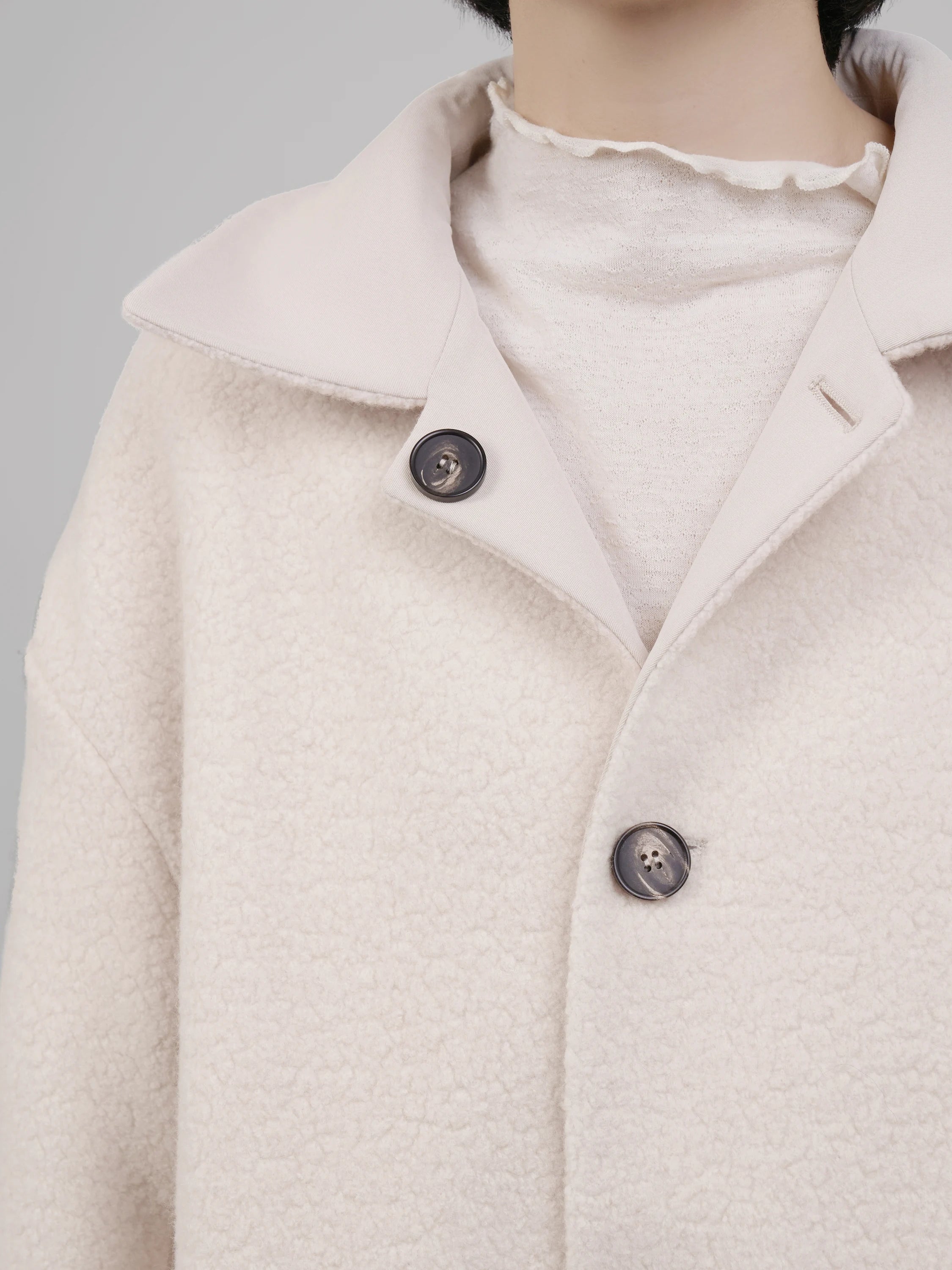 Fabric detail of reversible wool coat, highlighting texture, thickness and premium finish.