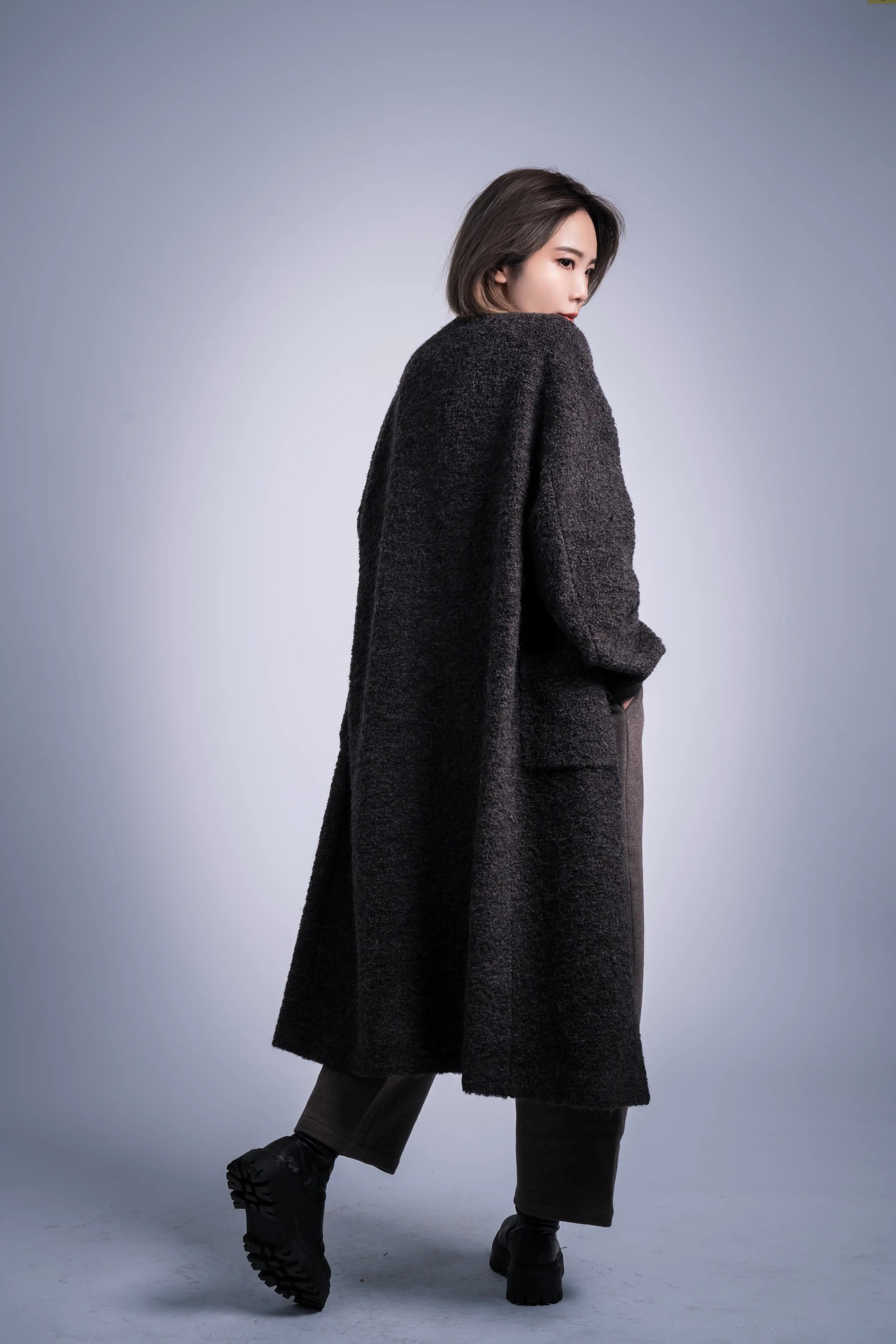 Back view showing clean long silhouette, minimal tailoring, alpaca-wool blend coat for winter styling.
