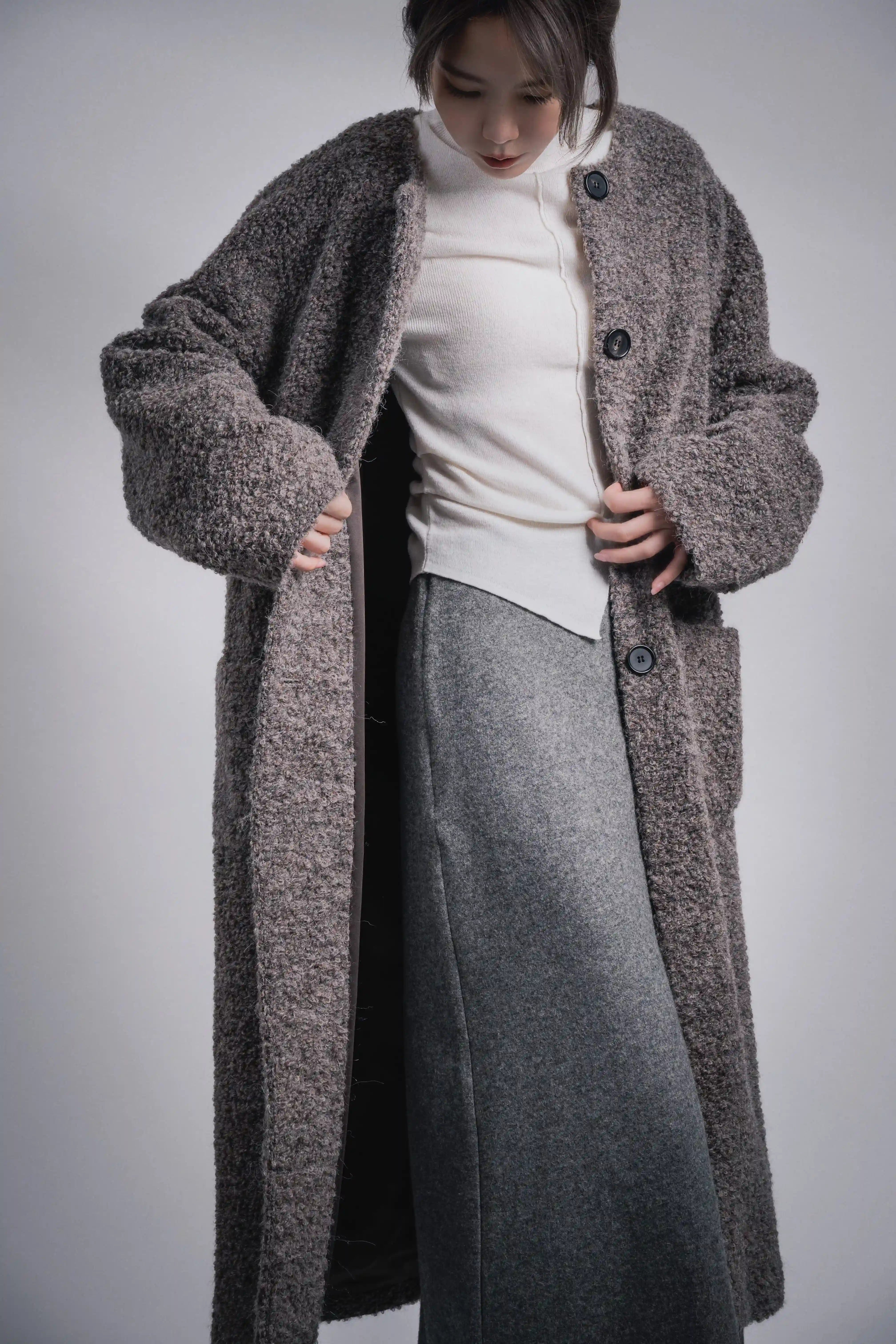 Front view styled with white knit top under grey alpaca wool coat, clean winter layering look.