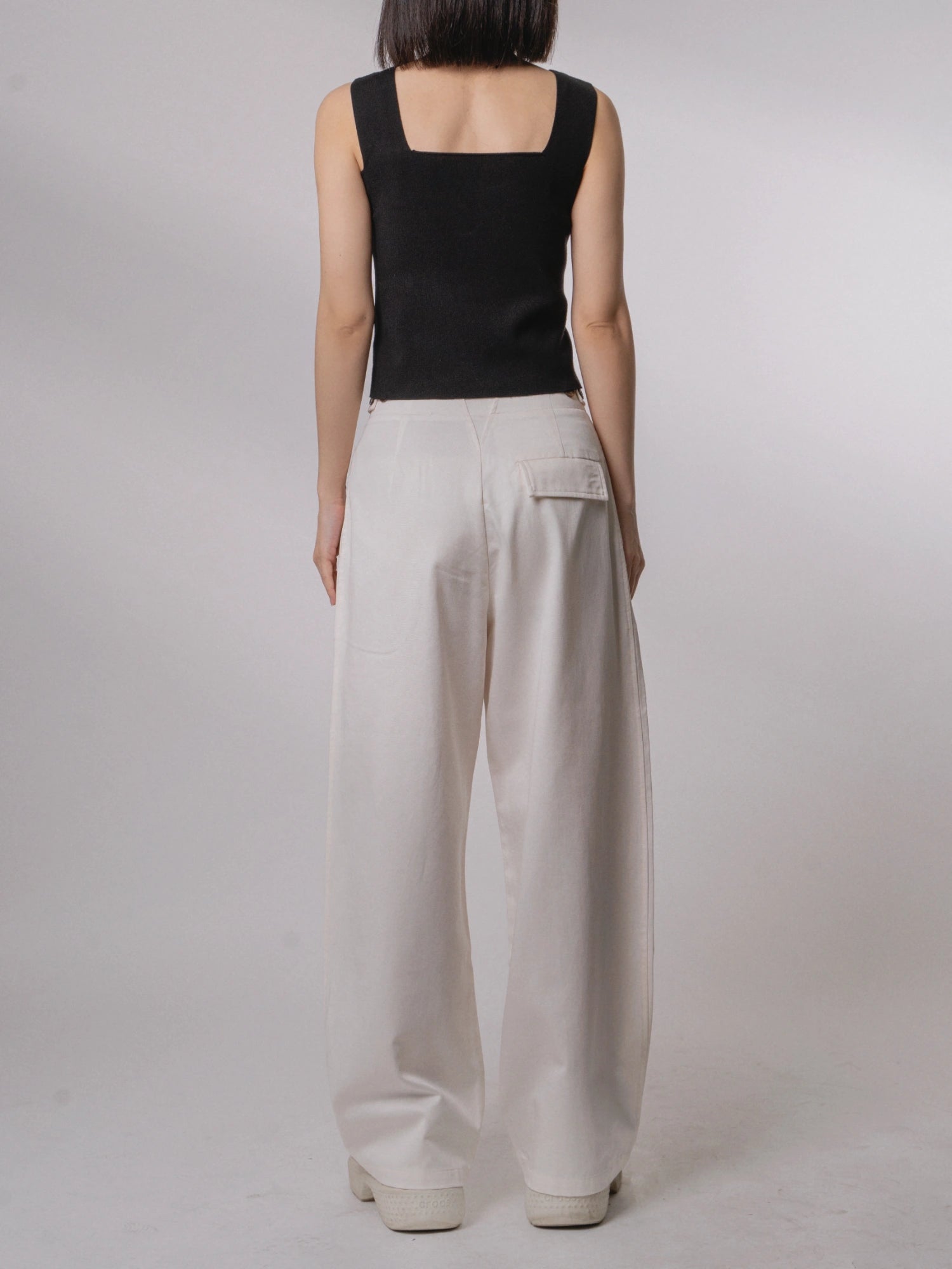 Back view of white Tencel-cotton trousers, soft structure and relaxed wide-leg cut for everyday comfort.