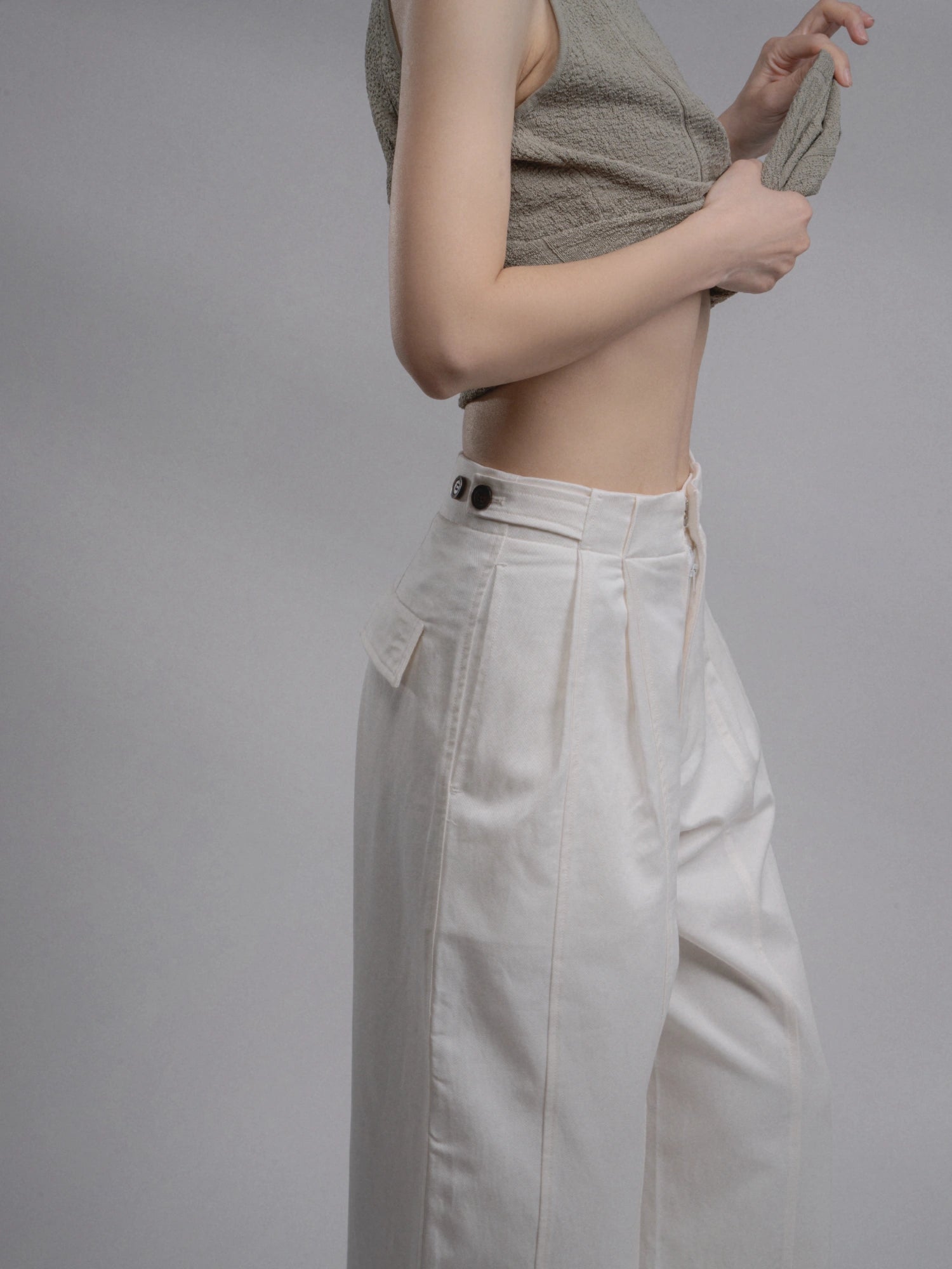 Side detail shot of white Tencel-cotton trousers showing natural drape and breathable lightweight fabric.