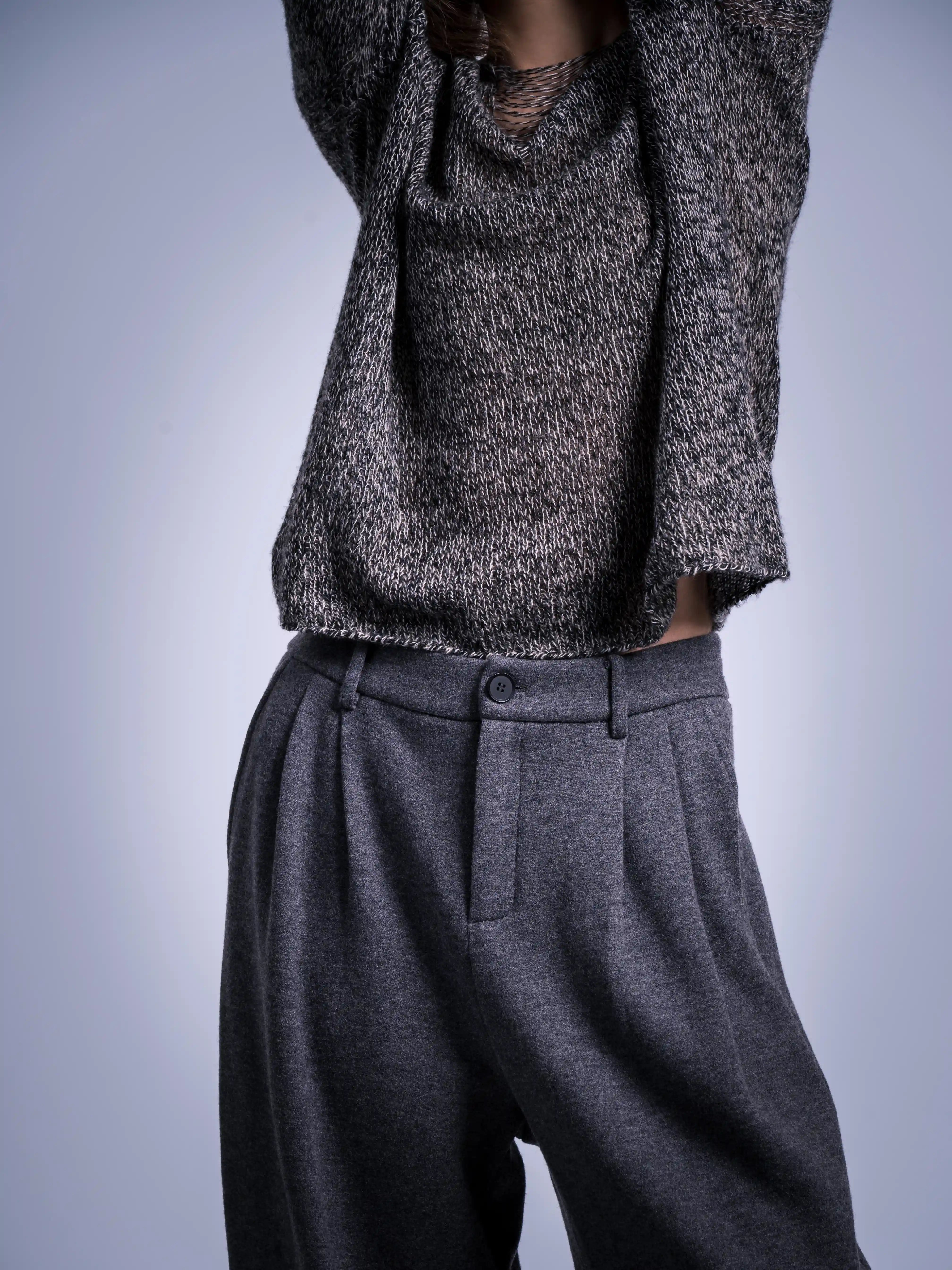 Detail close-up of waistband and texture, grey wool trousers with soft structured finish.