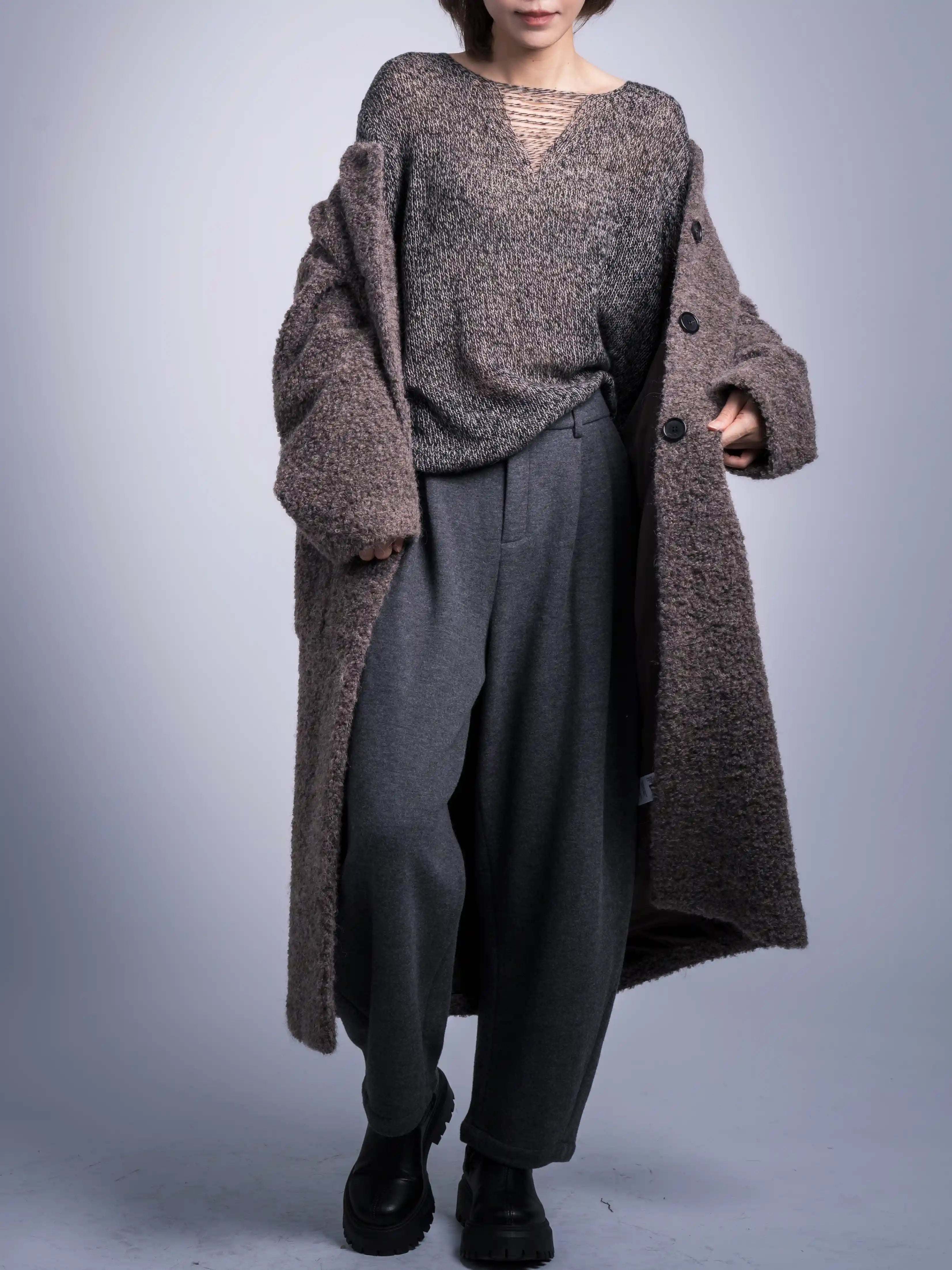 Layered winter outfit with grey wool trousers and long coat, clean tapered silhouette.
