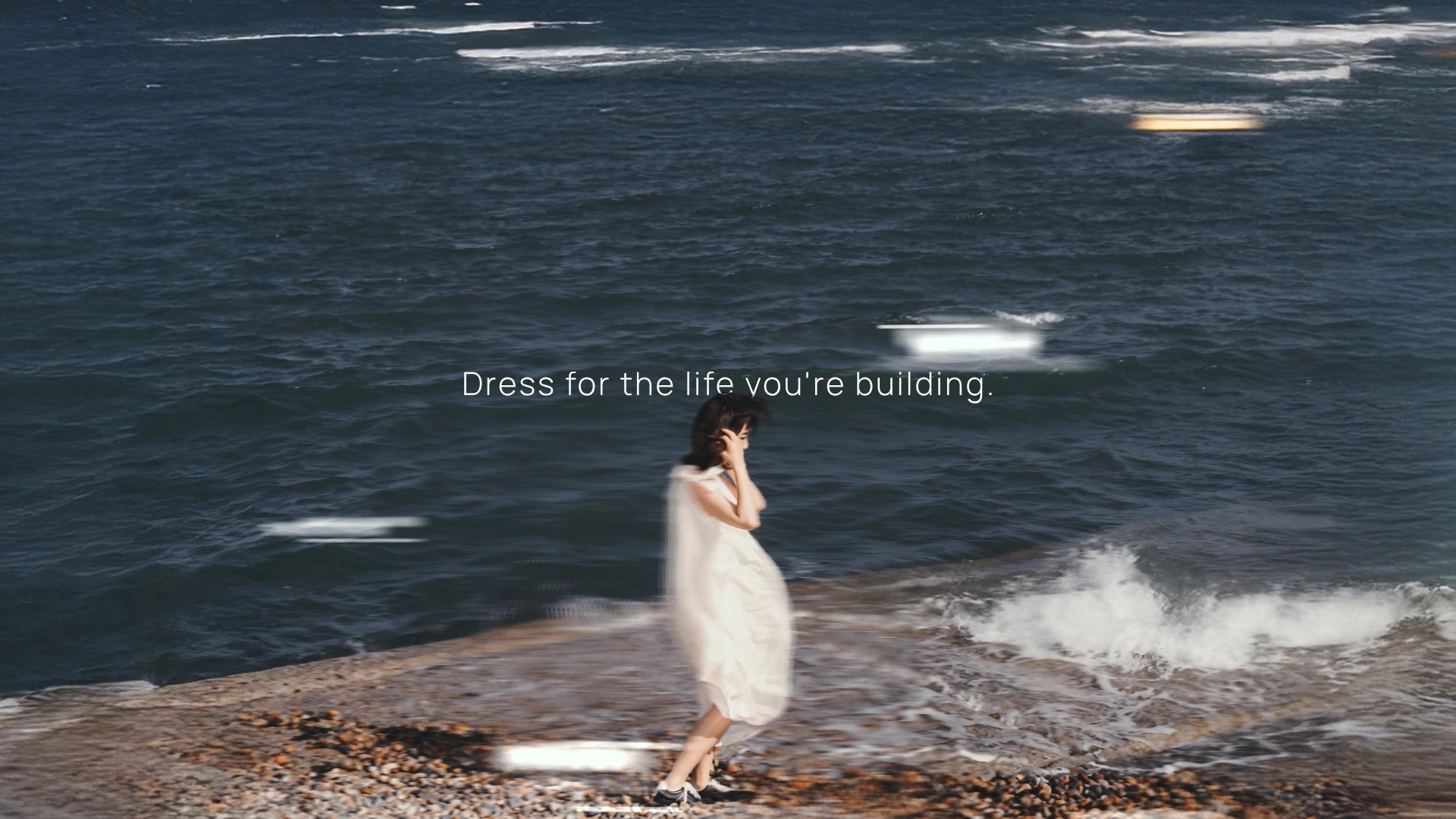 Woman walking along the seaside wearing minimalist clothing from XXLSMILE.