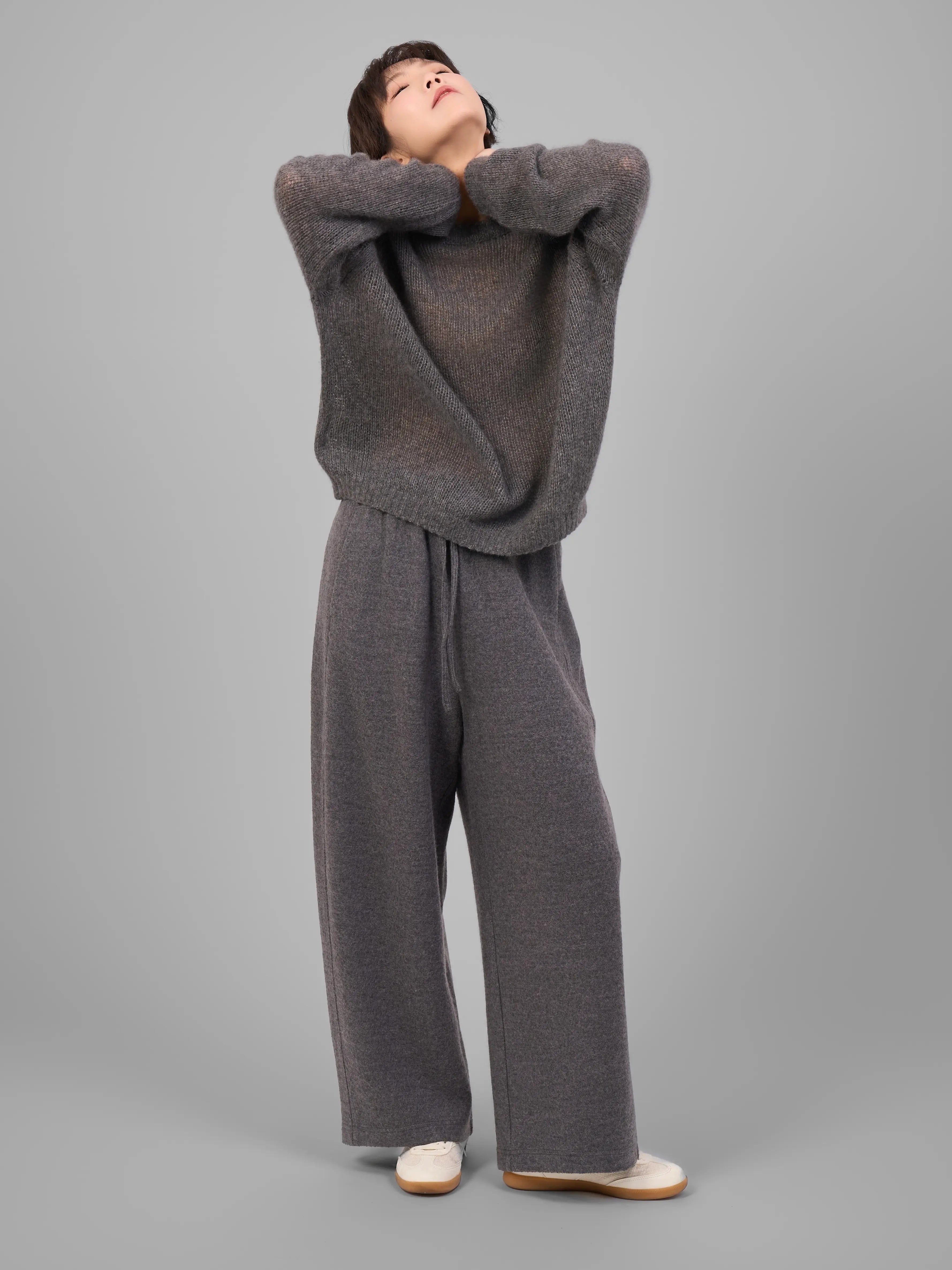 Full-body look of model wearing grey cashmere-silk knit sweater with wide-leg trousers.