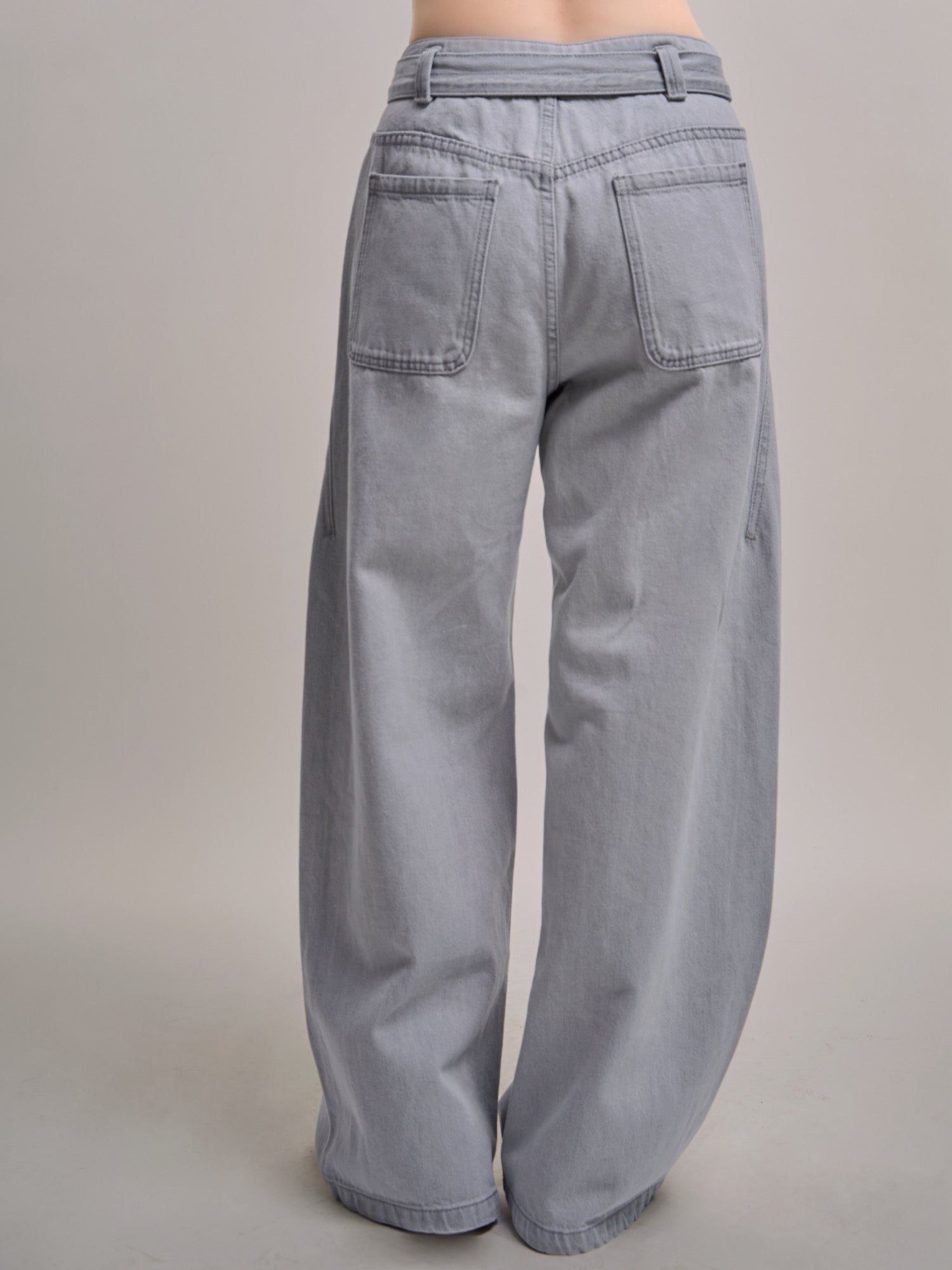 Back waistband and pocket detail of Curved Cocoon Jeans showing crafted seams and gentle volume.