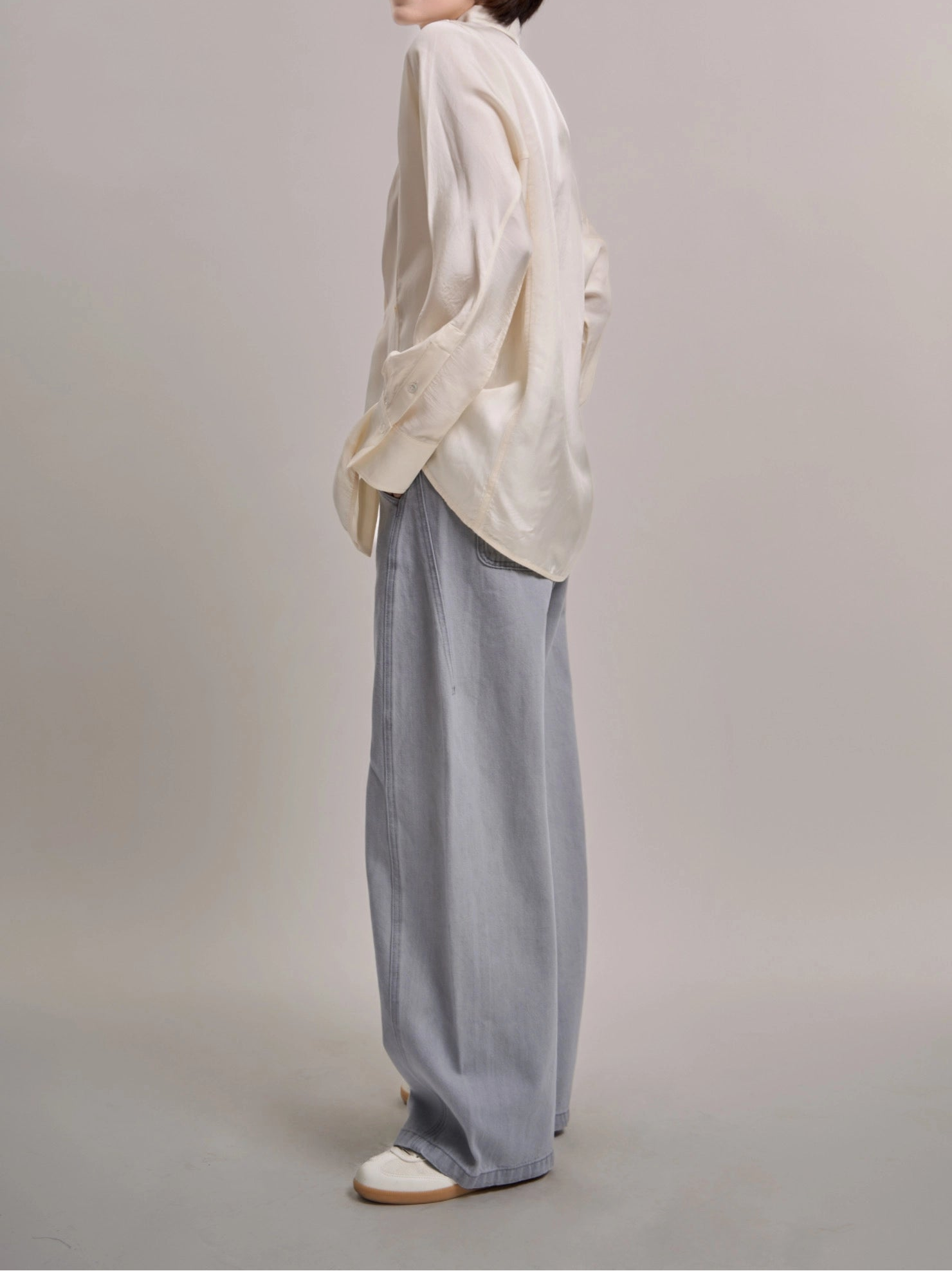 Side view of Curved Cocoon Jeans highlighting curved seams and soft movement in light blue denim.