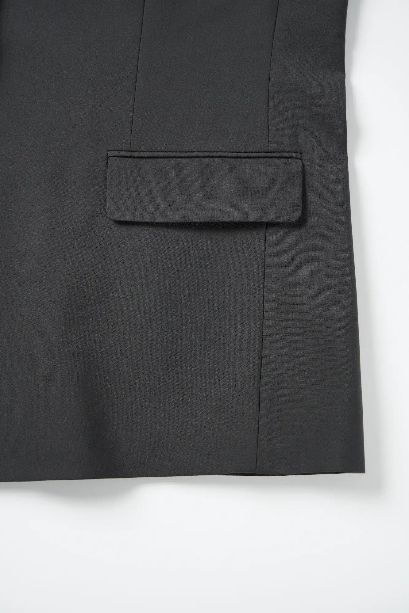 Detail view of the side flap pocket on the charcoal dropped shoulder blazer.