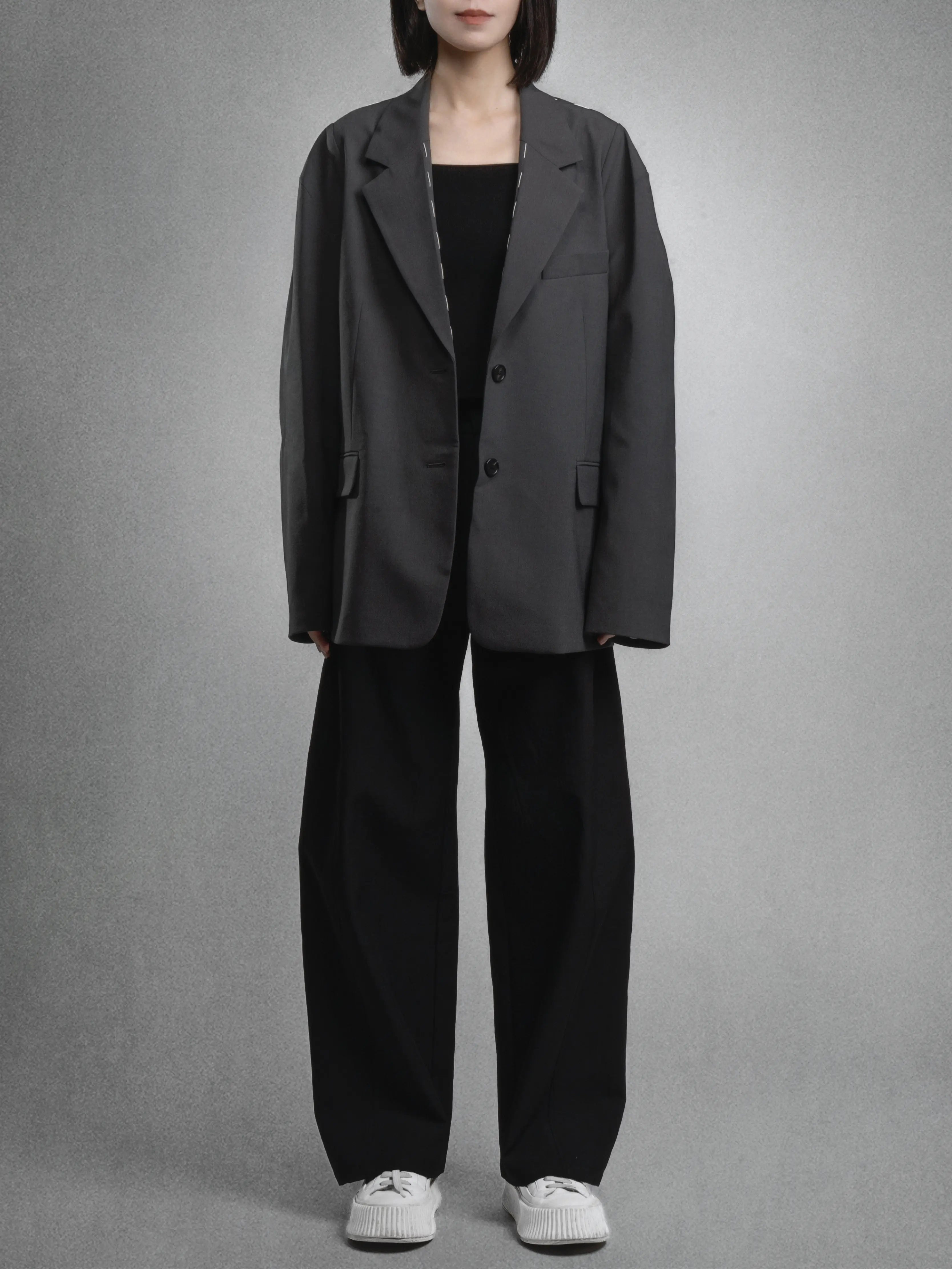 Charcoal dropped shoulder blazer paired with wide-leg tailored trousers, clean front styling, relaxed silhouette.