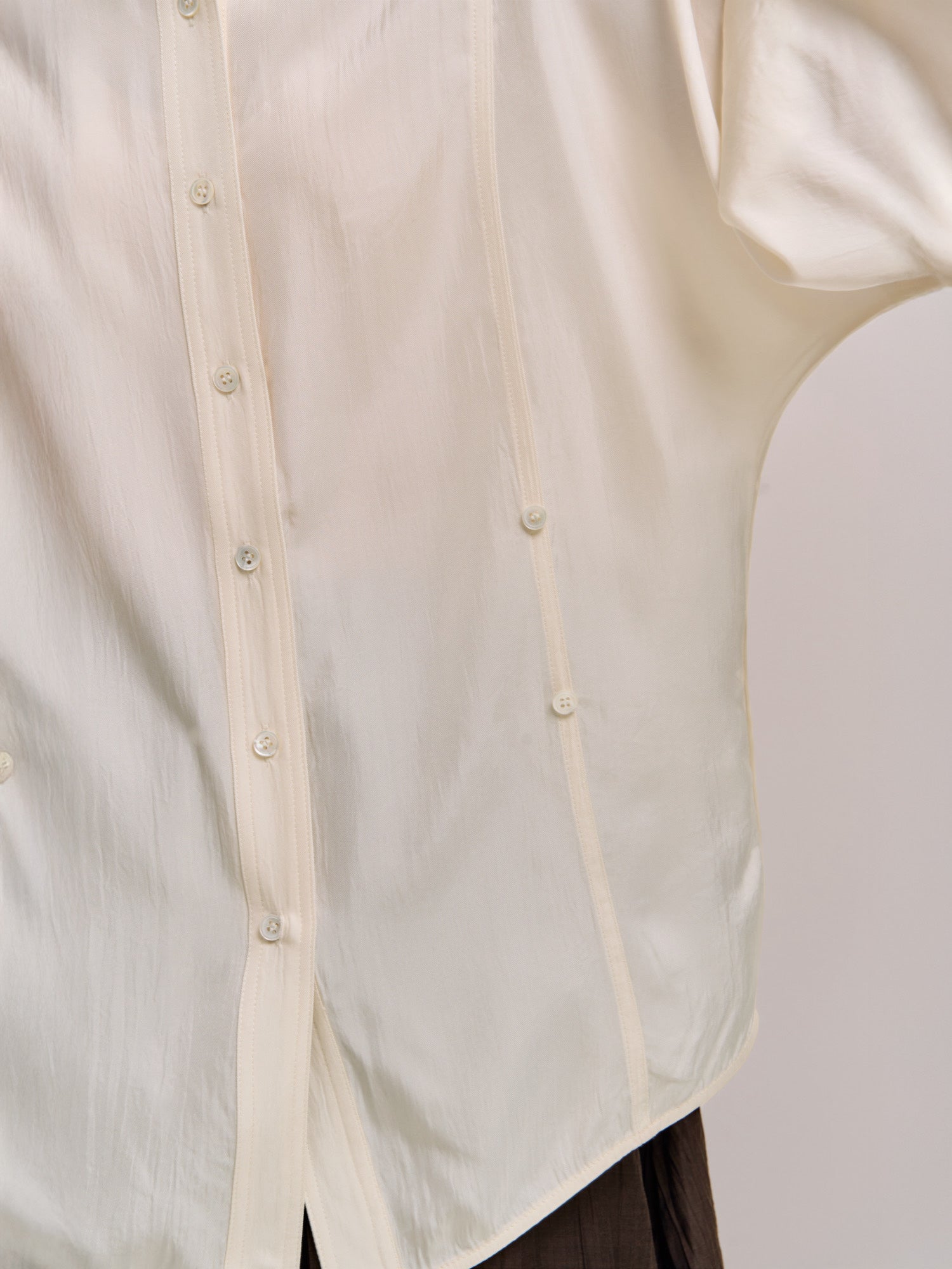 Close-up of dual-button detailing on ivory Dual Line Shirt showing two-way styling design.