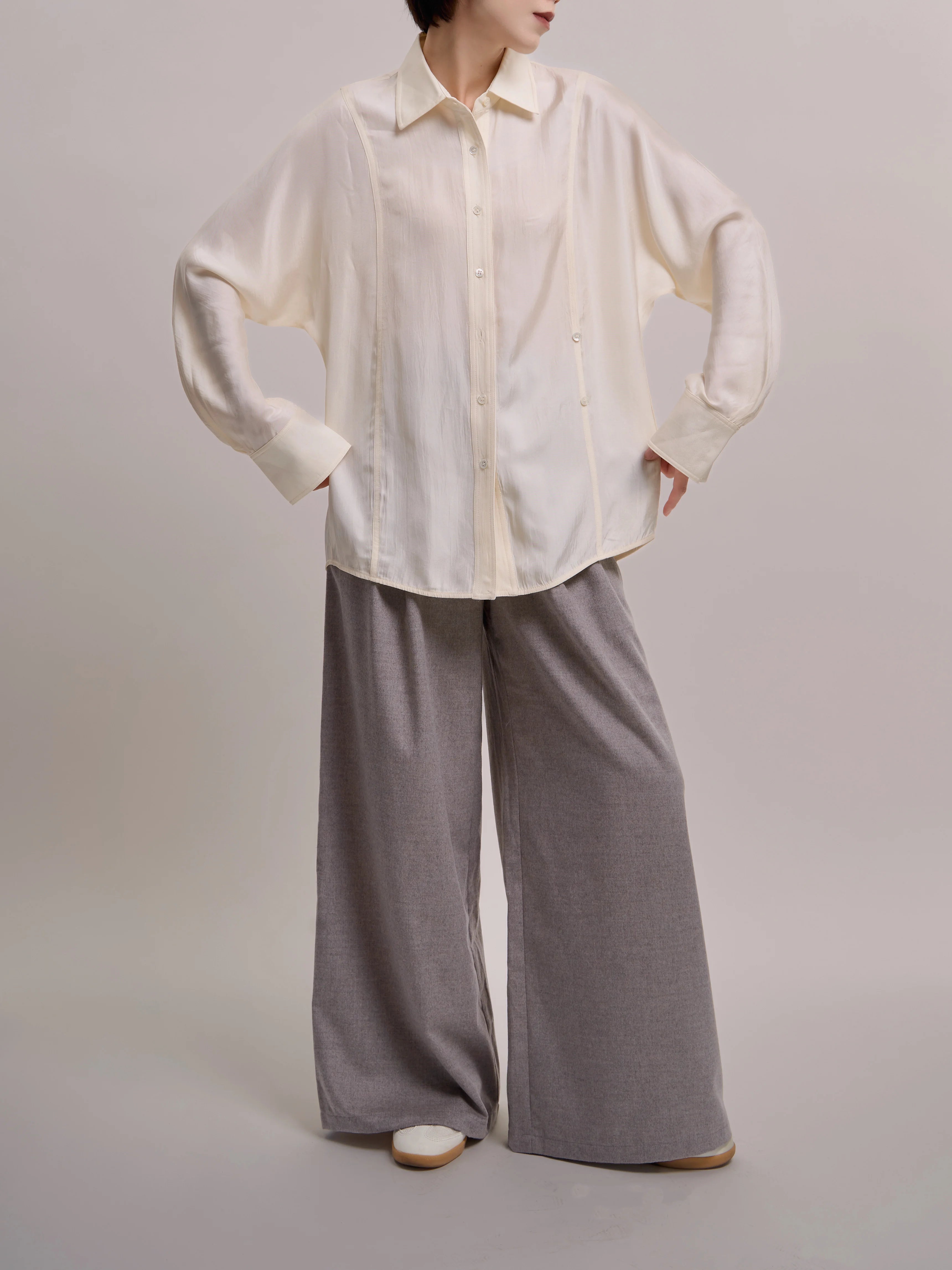 Front view of ivory Dual Line Shirt styled loose, showing batwing sleeves and dual-button structure.