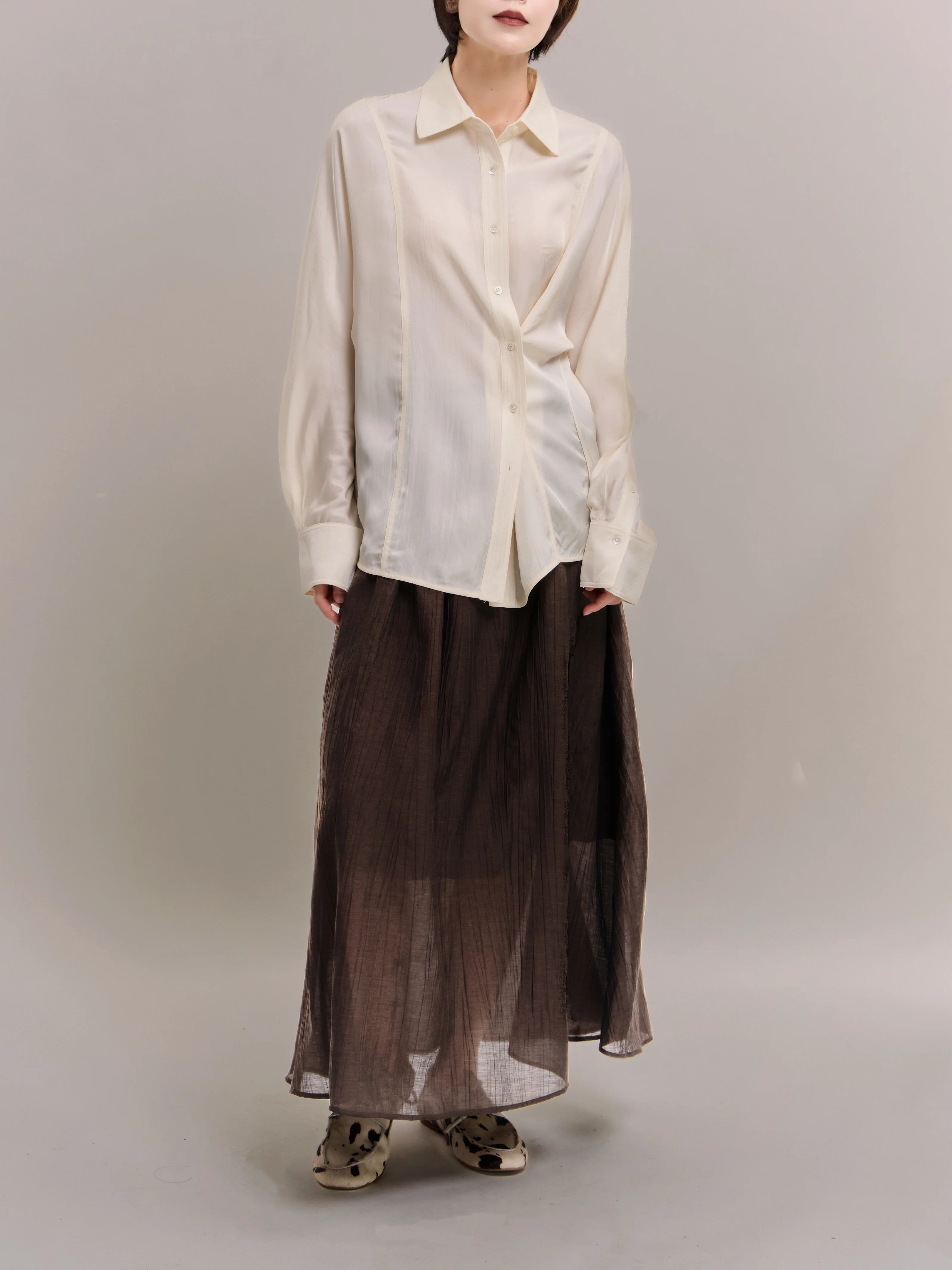 Model wearing ivory Dual Line Shirt with smooth acetate drape, full-body studio shot showing relaxed batwing sleeves.