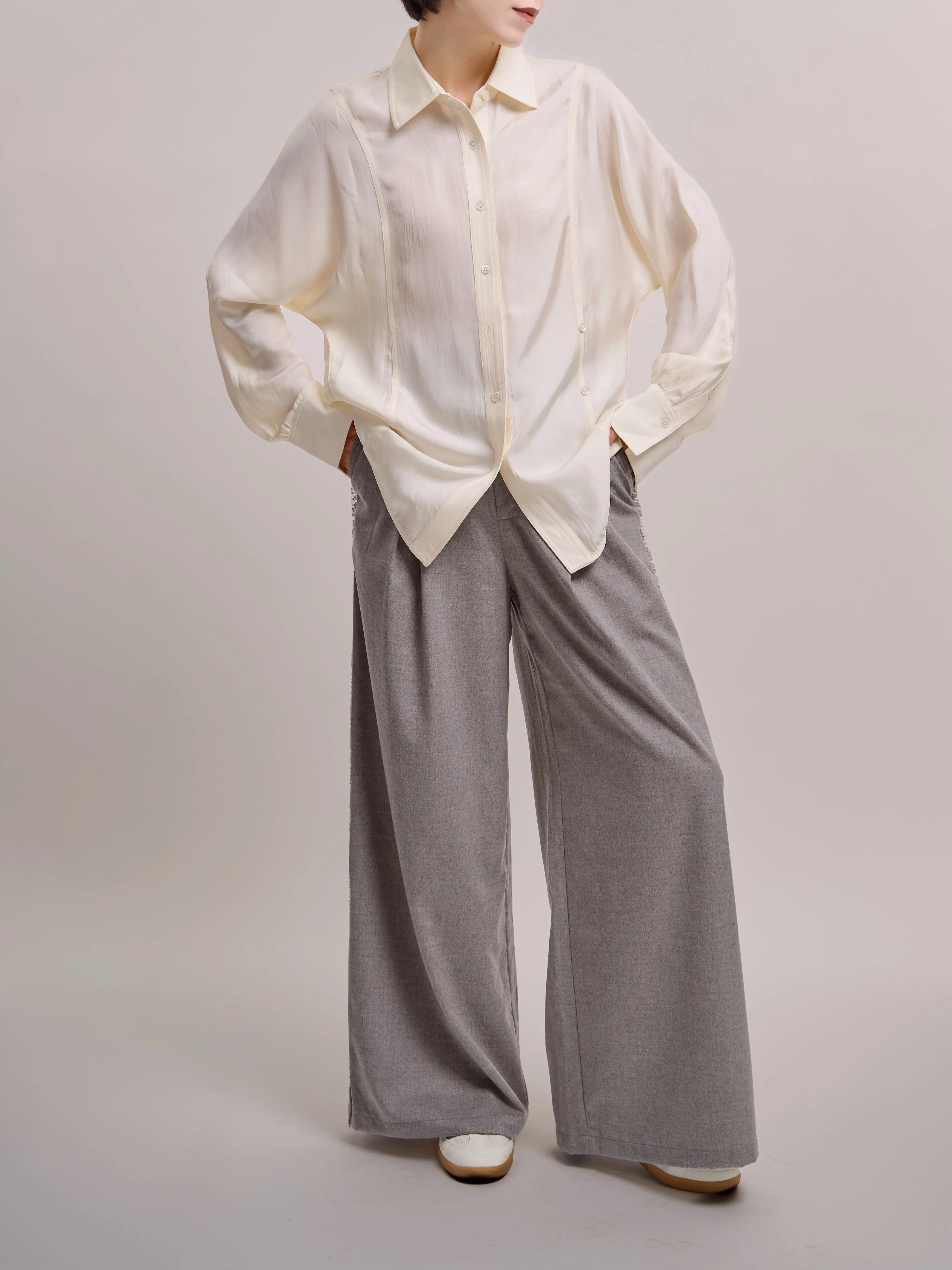 Side-angled view of ivory Dual Line Shirt showing soft structure and natural sleeve volume.