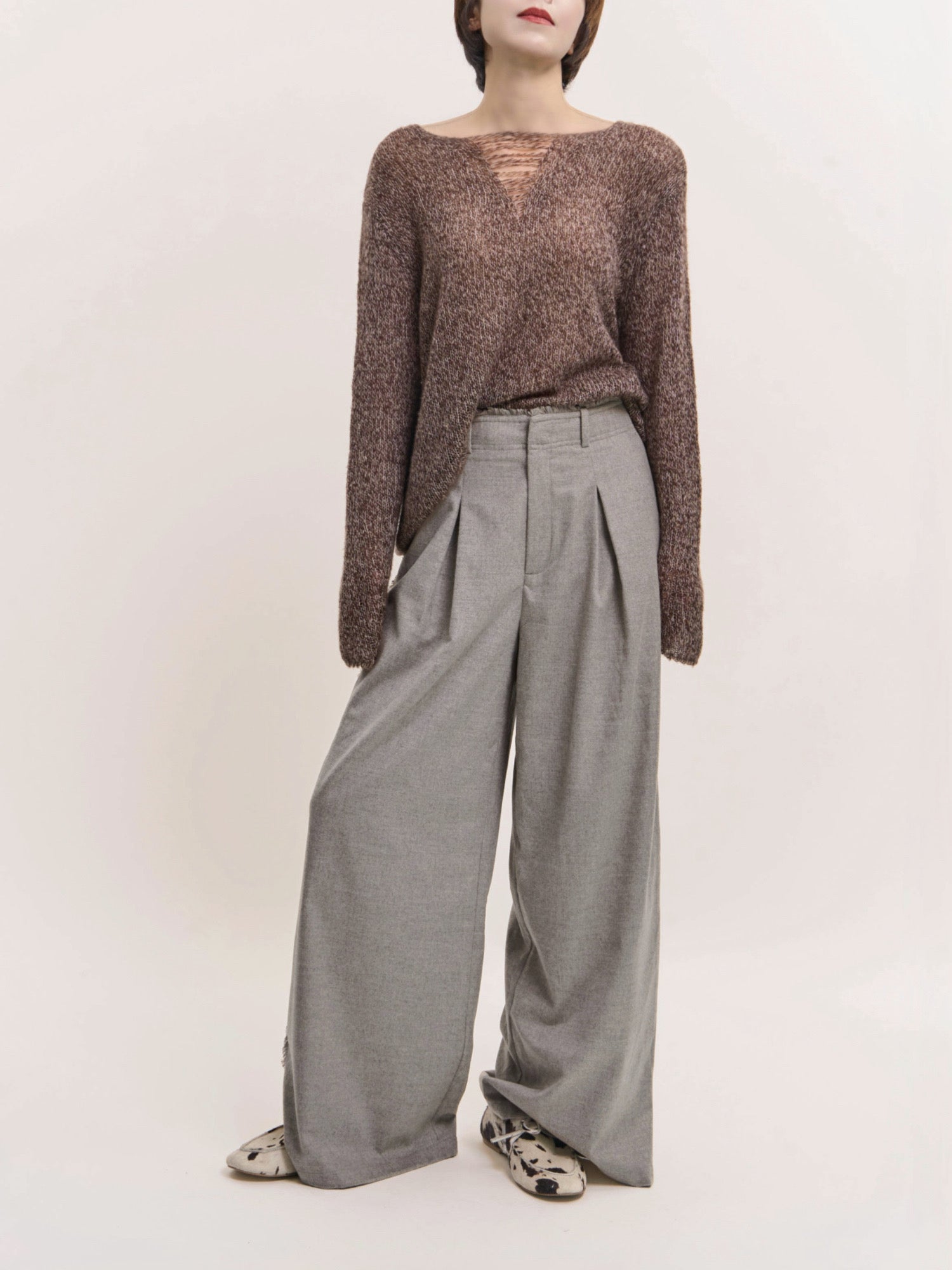 Front view of grey Edge Wool Pants showing wide-leg drape and clean pleated structure.