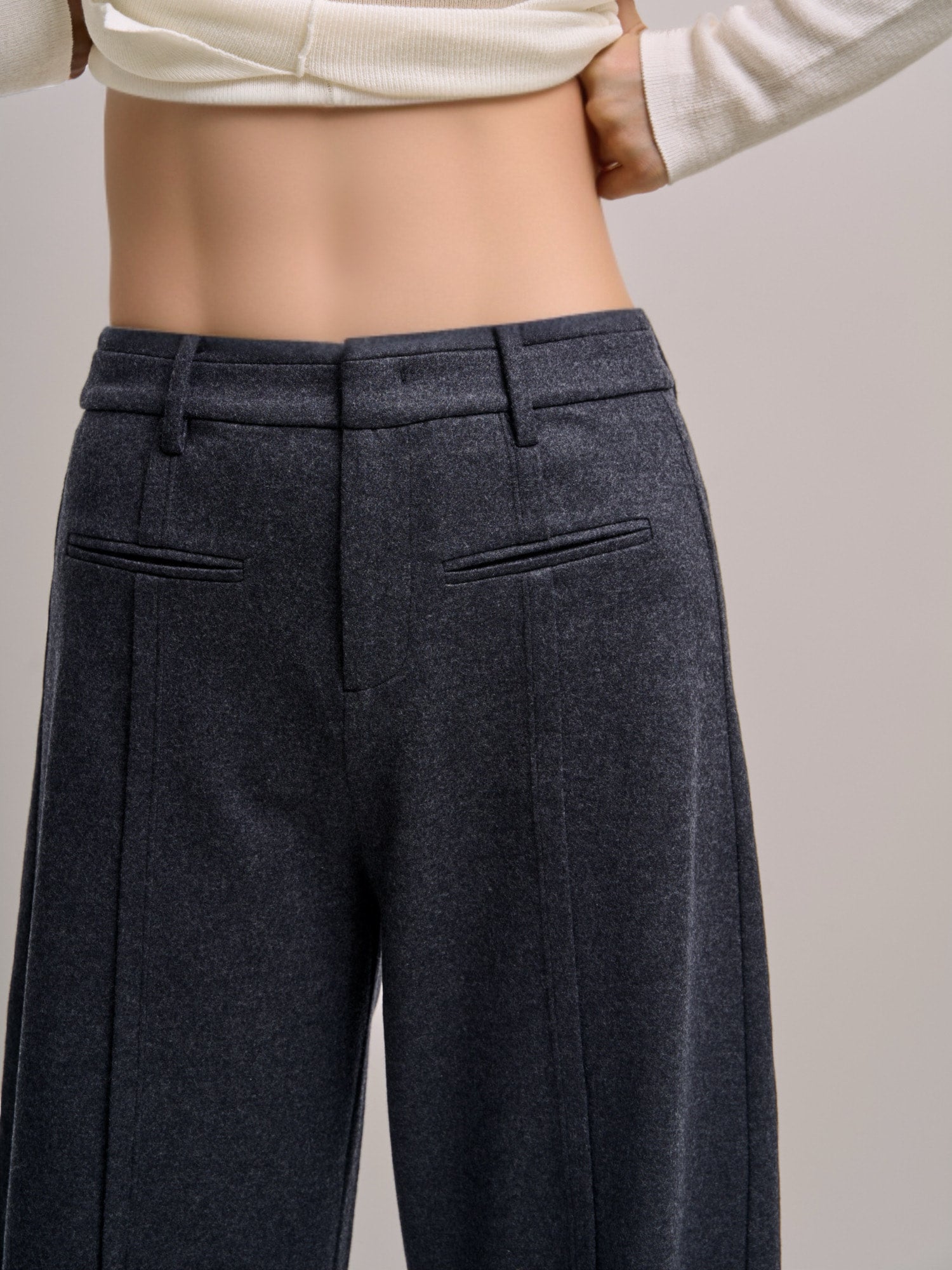 Back view of Minimalist Wool Pants highlighting clean waistband, welt pockets and tailored structure.