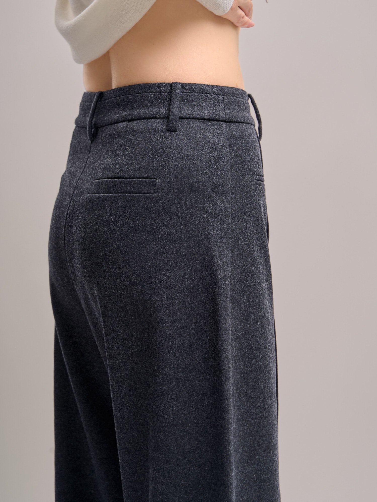 Rear-side angle of Minimalist Wool Pants showing smooth lining drape and modern wide-leg profile.