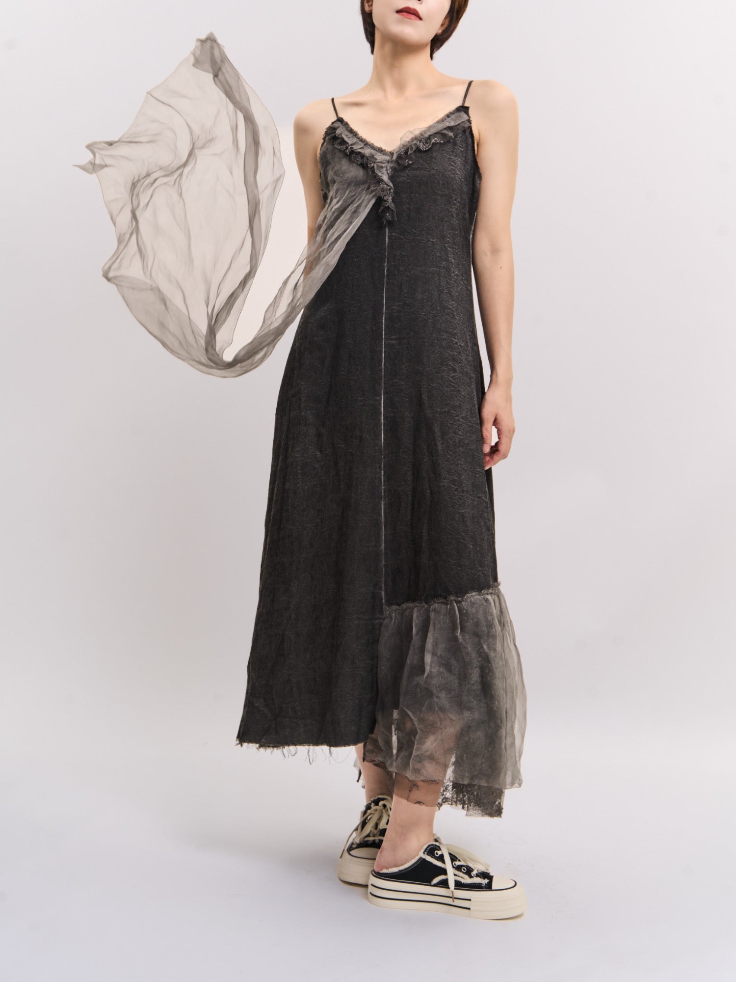 Model wearing charcoal Mist Veil Dress with mulberry silk overlay, full-body studio shot showing fluid asymmetric hem.