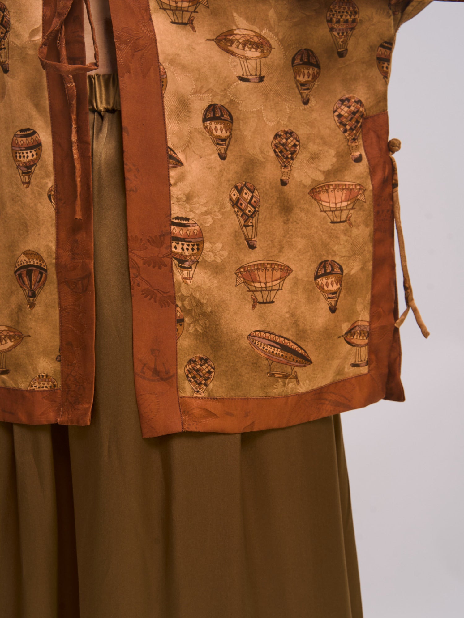 Close-up detail of mulberry silk Xiangyunsha top showing jacquard texture and contrast trim.