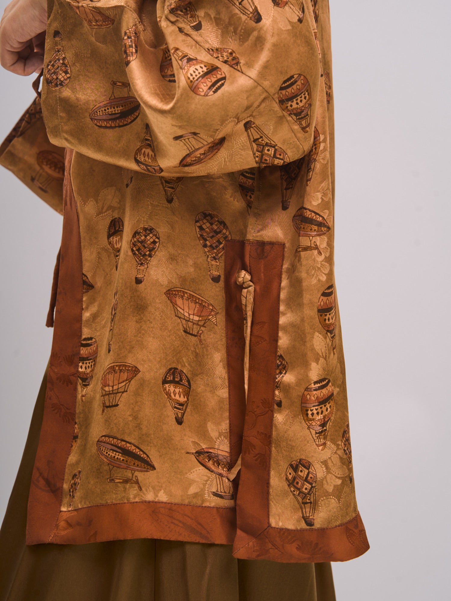 Side-back detail of mulberry silk Xiangyunsha top highlighting textured jacquard and side tie detail.