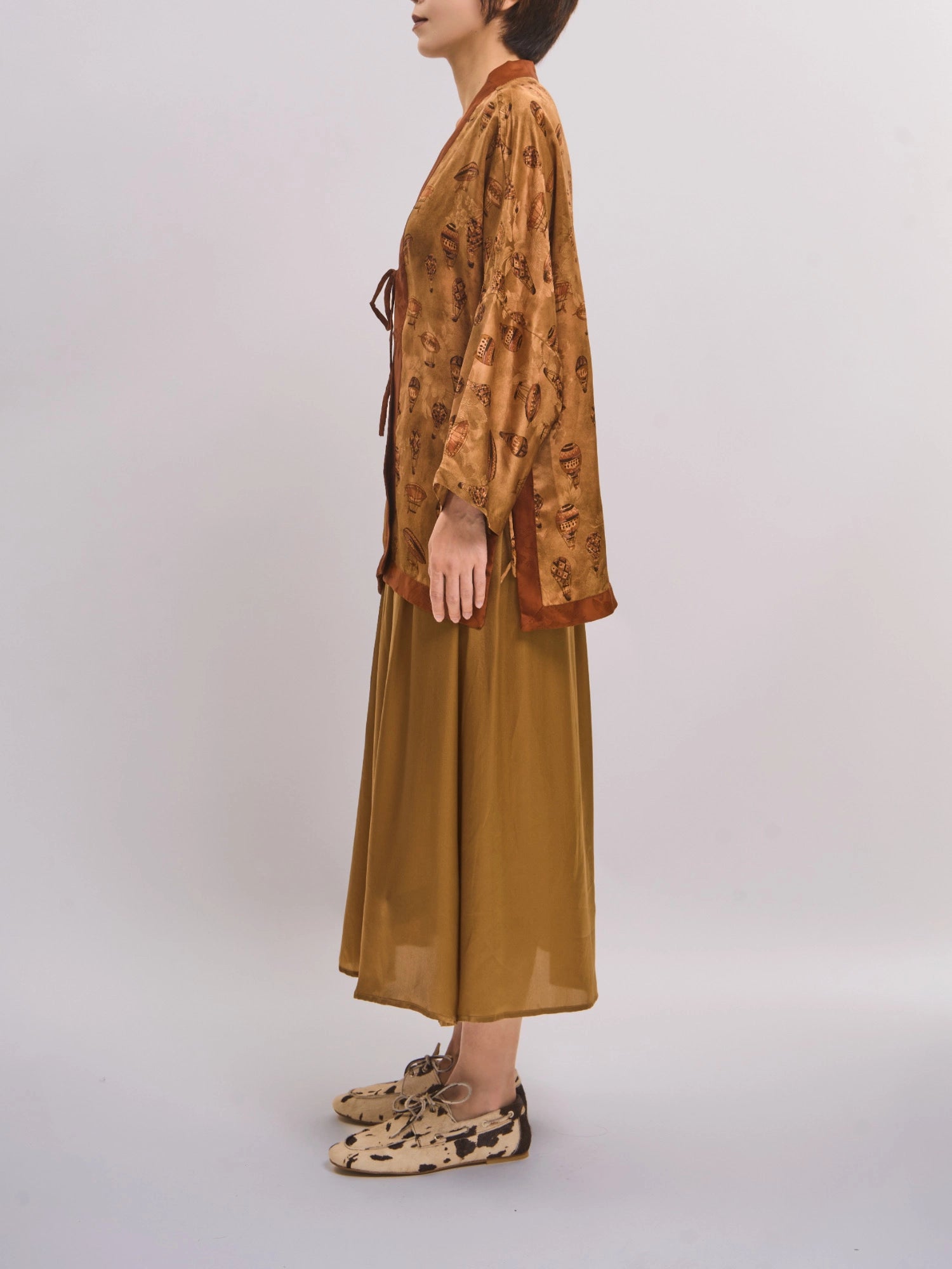Side standing view of mulberry silk top showing clean open-front line and relaxed sleeves.