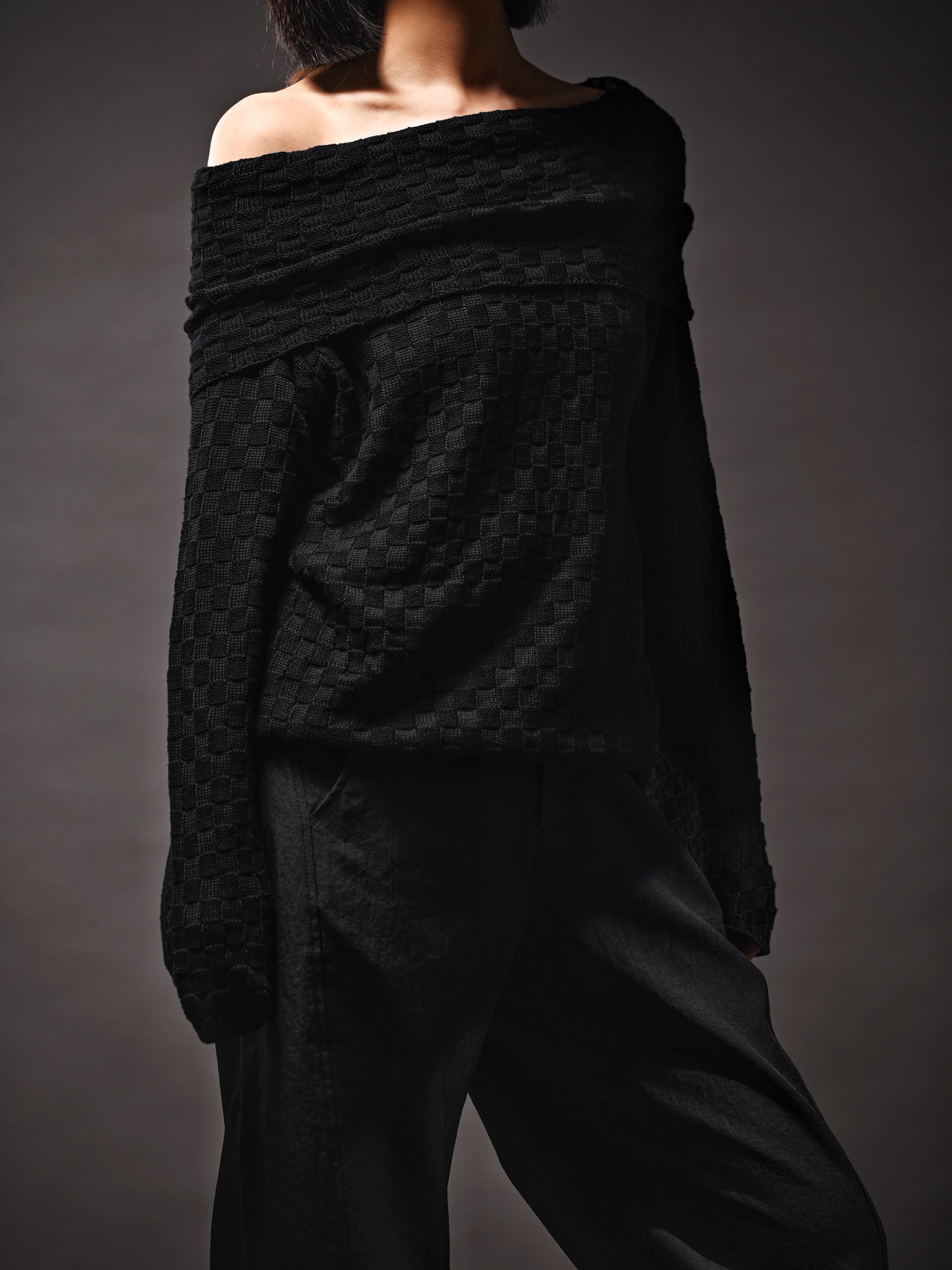Back view of off-shoulder textured black top, relaxed fit, soft drape and clean shoulder line.