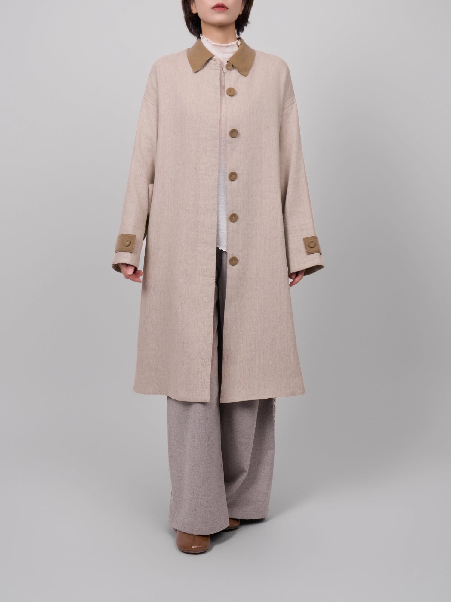 Front-standing shot of beige Rain Dew linen–wool coat buttoned up, clean hidden placket and straight line.