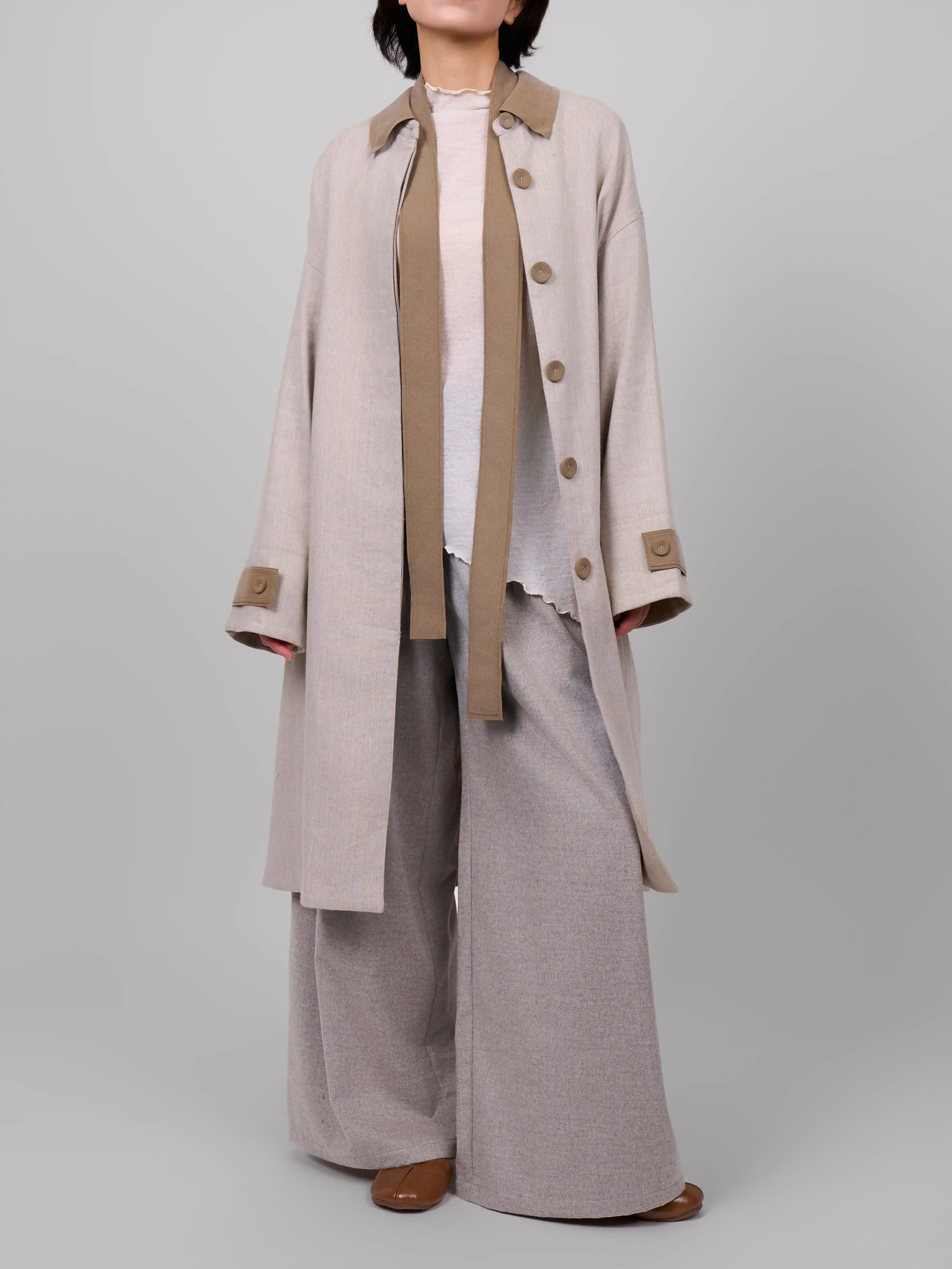 Model wearing XXLsmile rain dew linen wool coat in beige open front full body studio look relaxed oversized fit